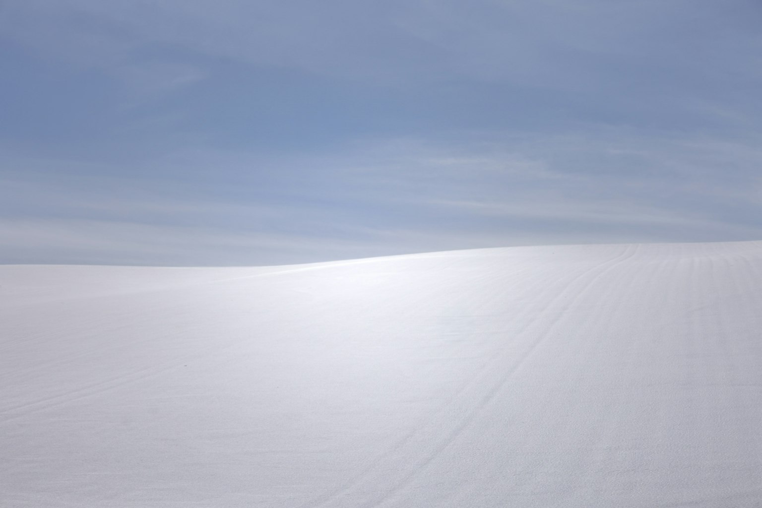 Vaste champ de neige blanche sous un ciel bleu