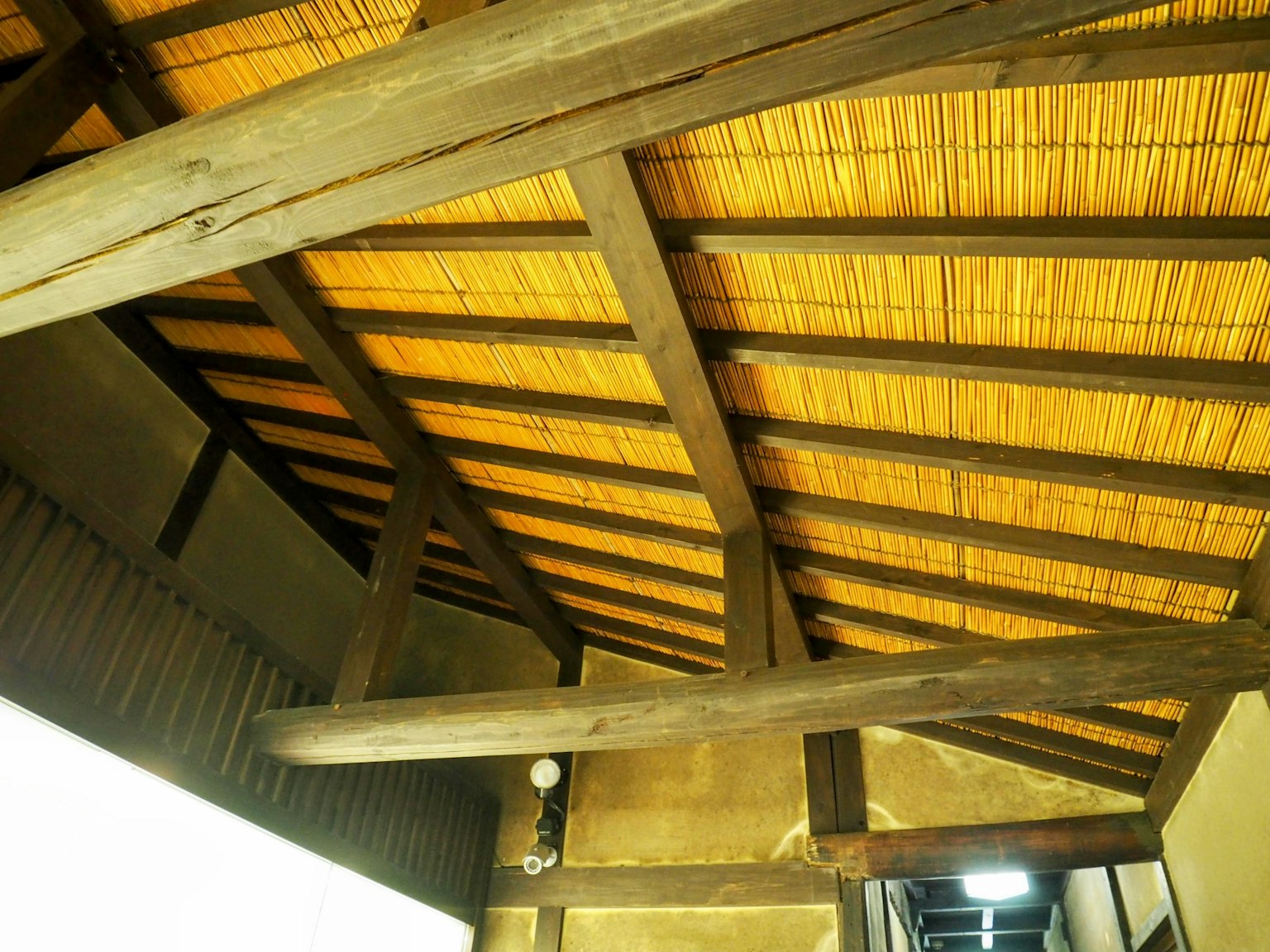 Interior bangunan tradisional dengan balok kayu dan atap bambu