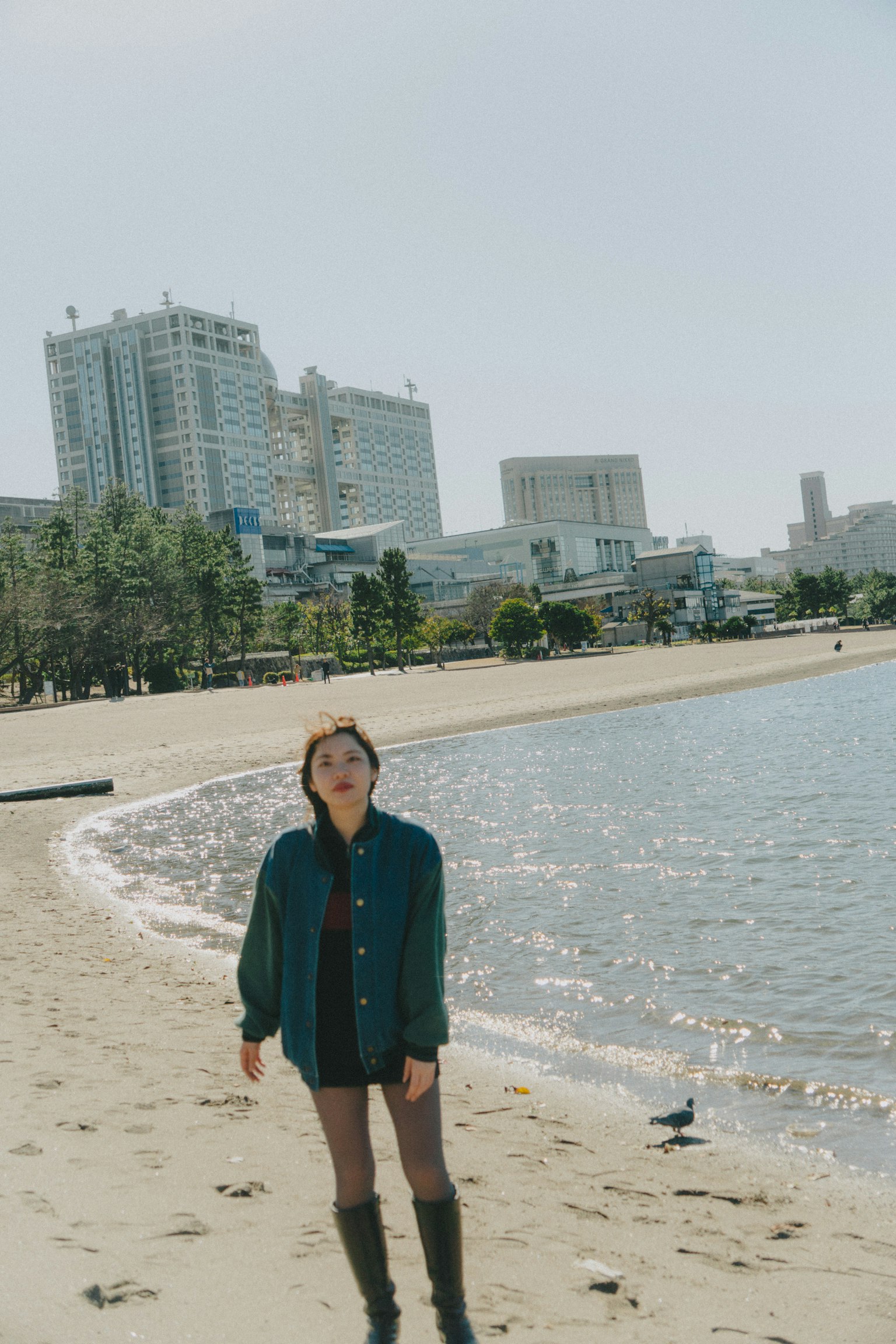海灘上擺姿勢的女性與背景中的高樓大廈
