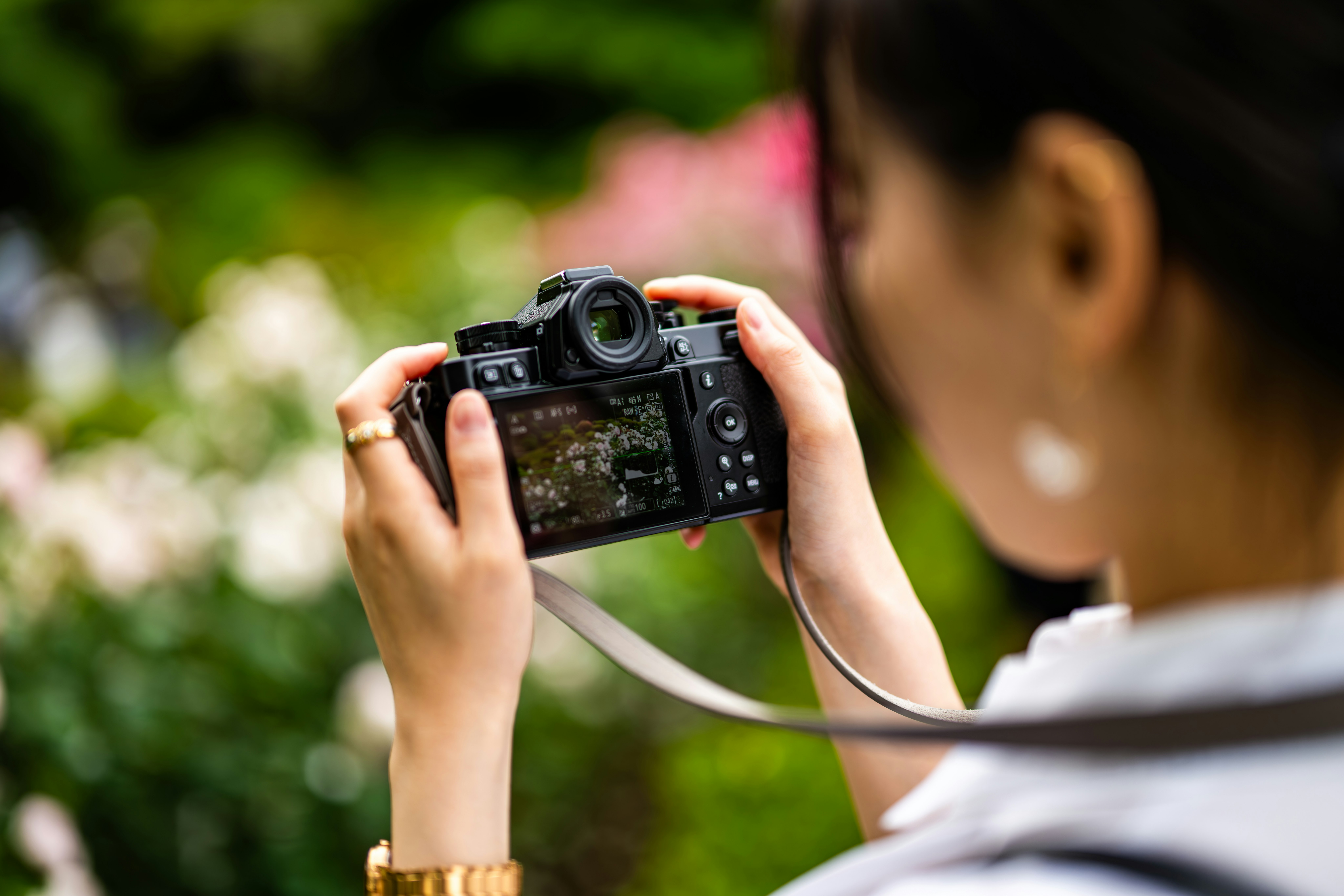 back view of a person holding a camera in a park