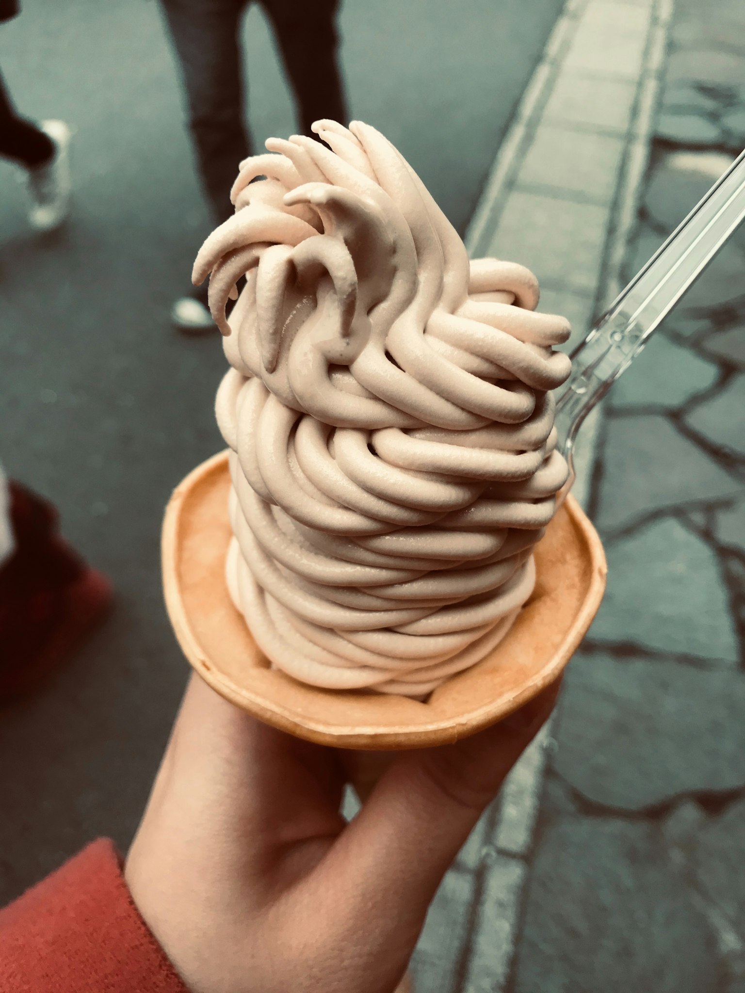 Sebuah tangan memegang es krim Mont Blanc dalam cone