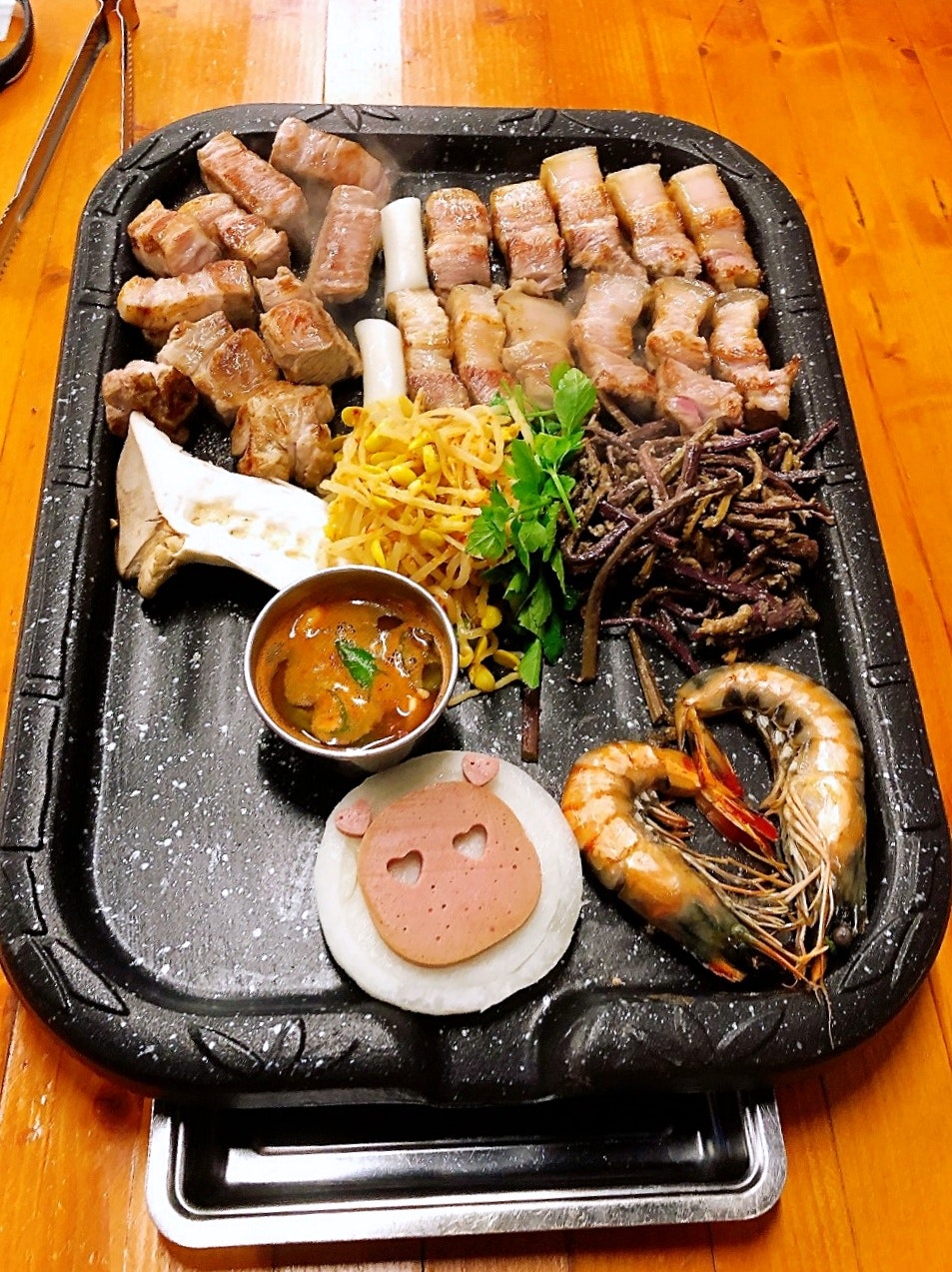 đĩa đồ nướng kiểu hot plate với tôm, xúc xích và nước chấm