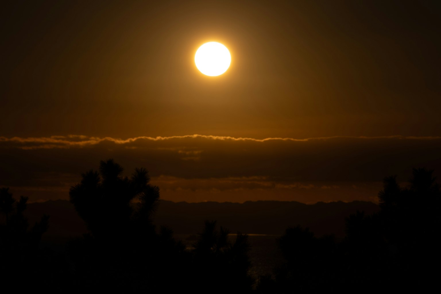 Beautiful sunset with the sun shining above the clouds