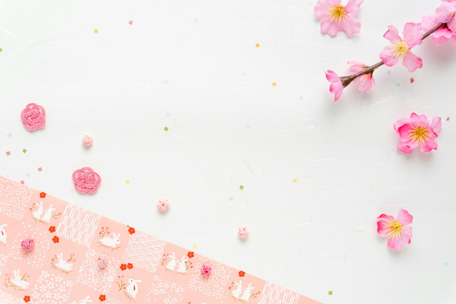 Fondo blanco con pétalos de cerezo y decoraciones rosas esparcidas