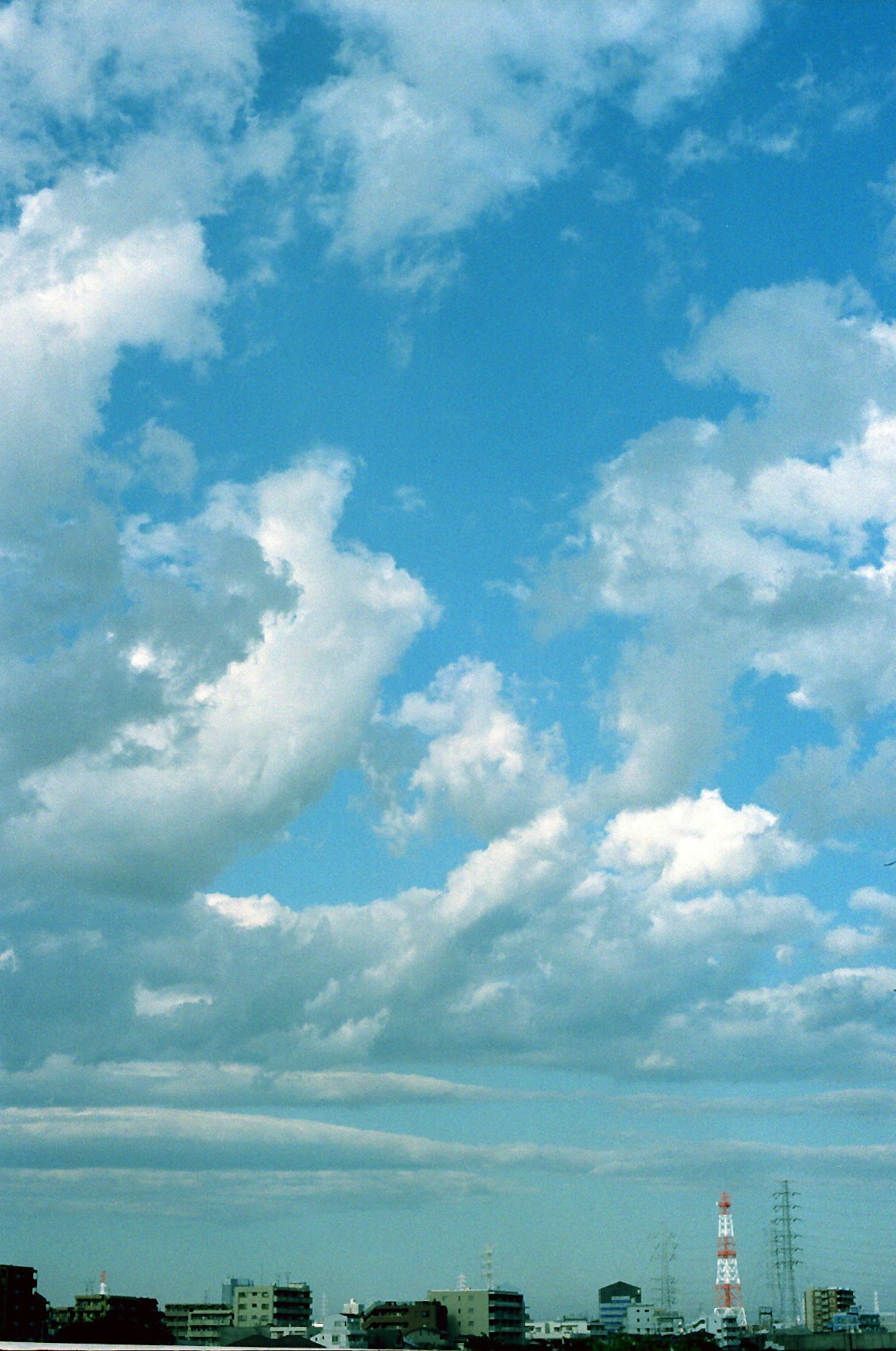 Blue sky with white clouds and city skyline