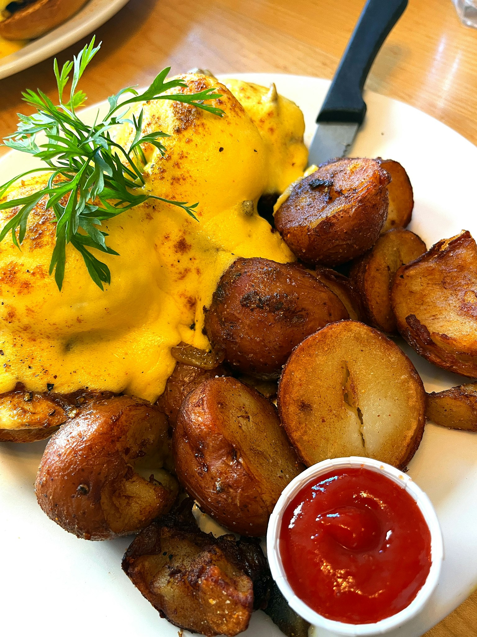 Uova benedicta con salsa olandese gialla servite con patate arrosto