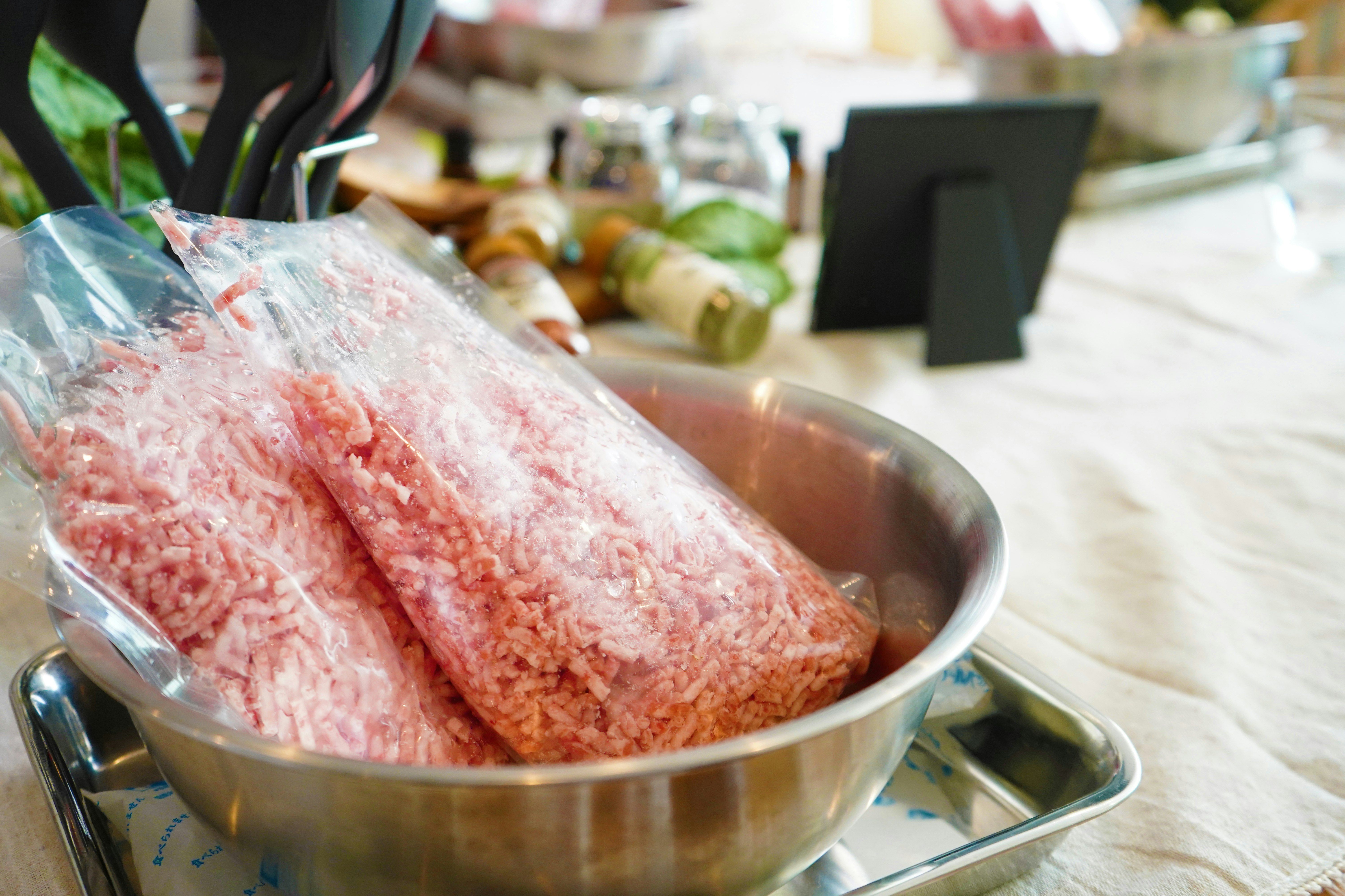 冷凍された挽肉が入った透明な袋が銀色の皿に置かれている