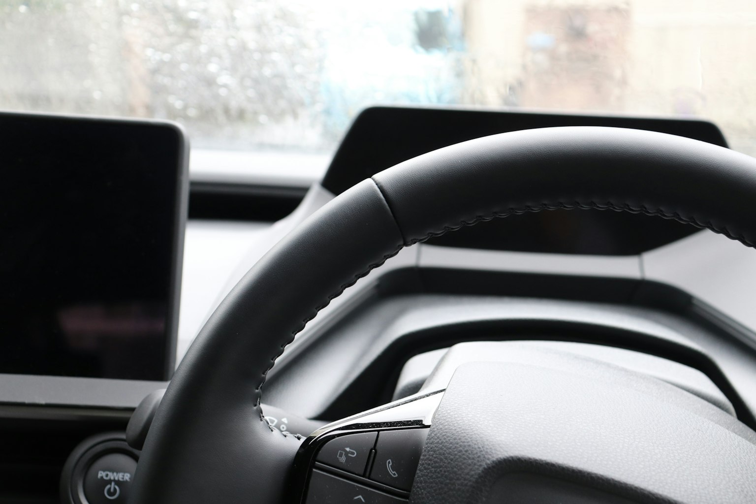 Primo piano di un volante di auto e schermi digitali