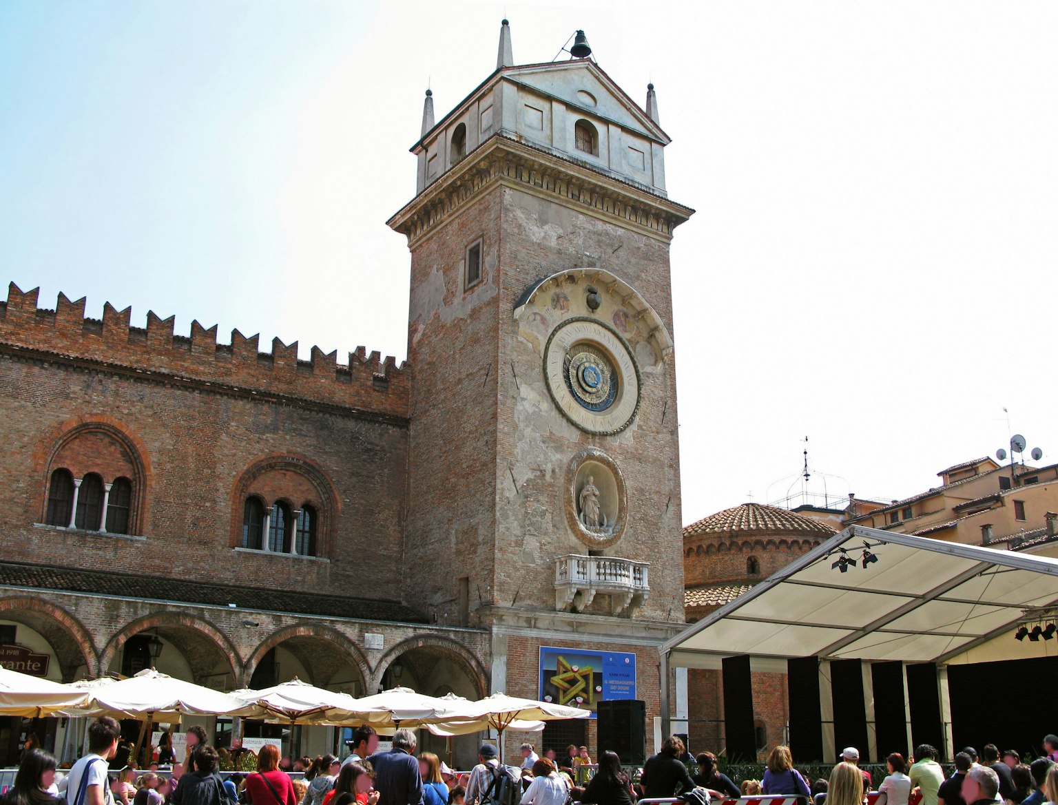 Tour de l'horloge historique dans une place animée avec des gens rassemblés