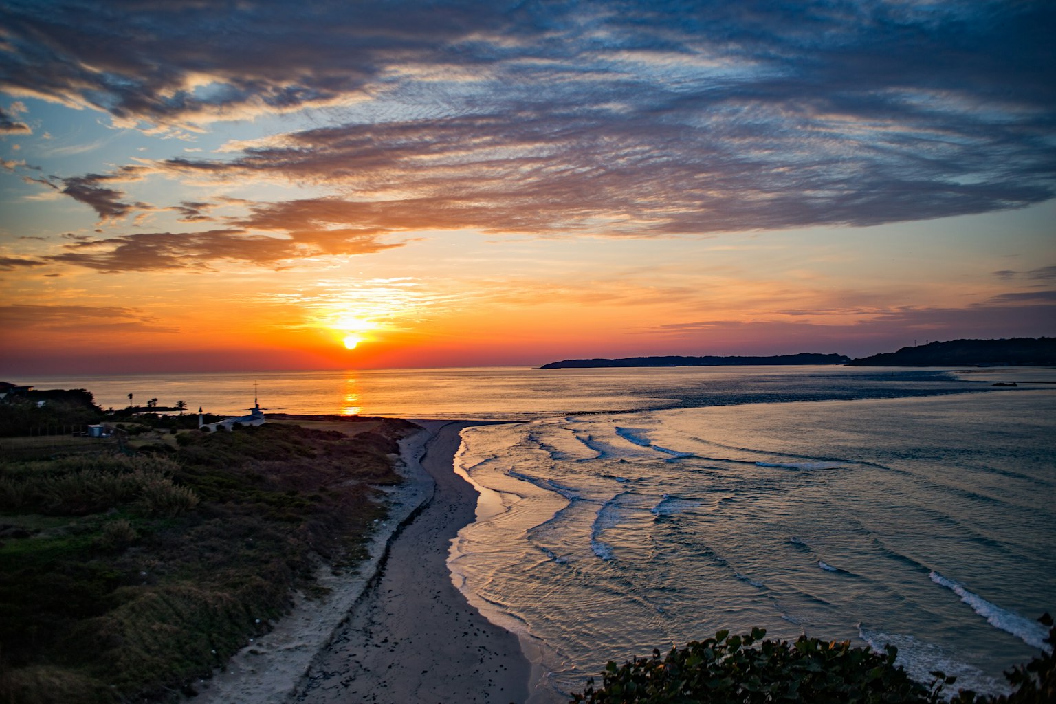 Sunset over the coastline with waves