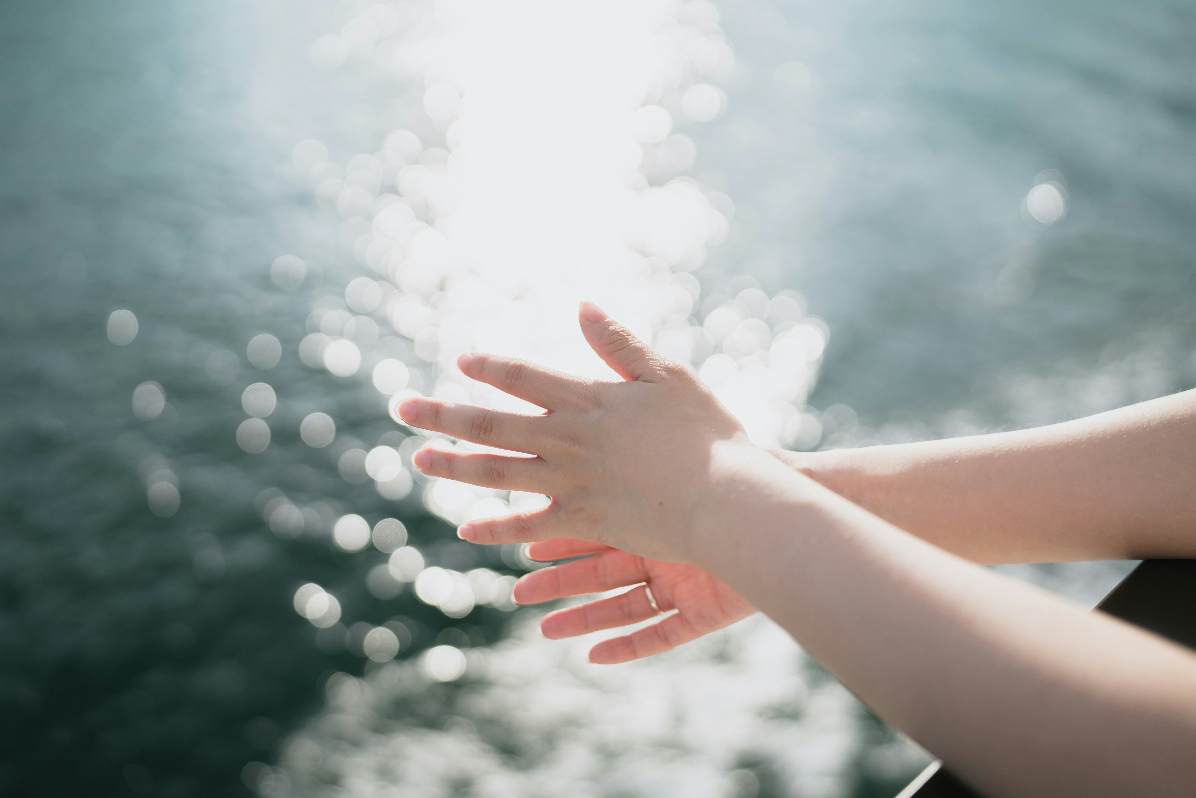 海辺で手を重ねる人のシルエット