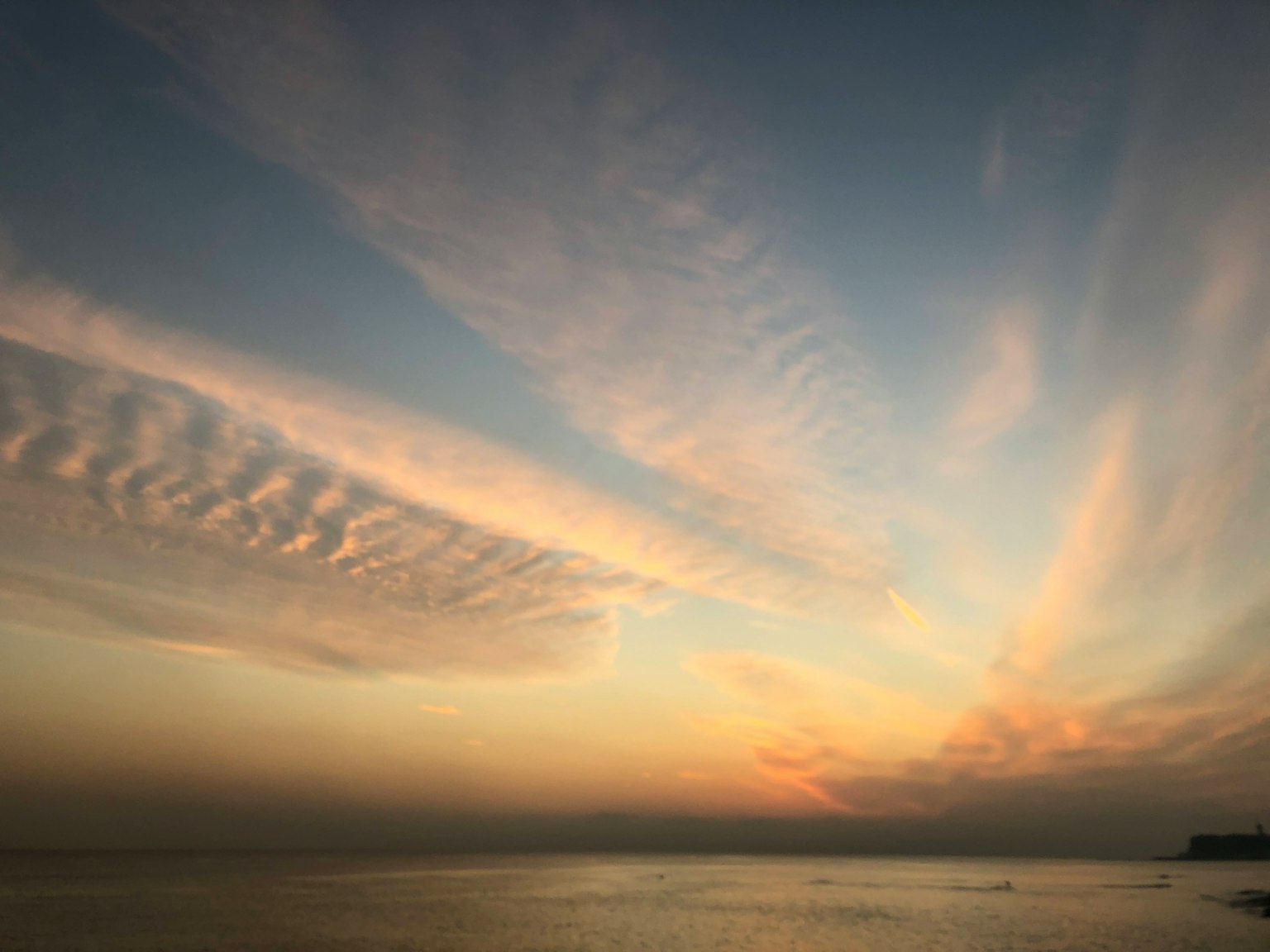Cielo al tramonto sopra l'oceano con schemi di nuvole in luce soffusa