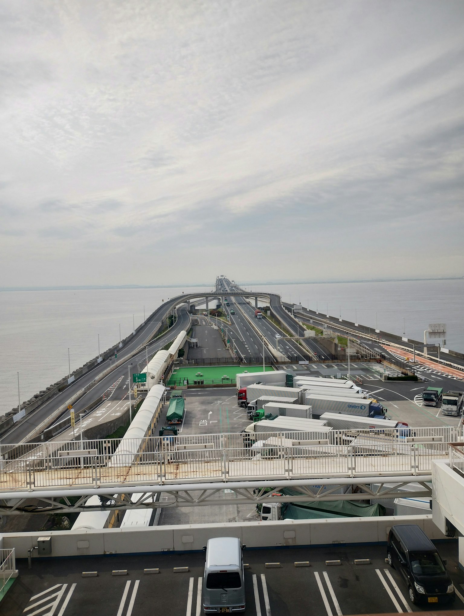 Una vista de una carretera que se extiende hacia el mar con camiones alineados