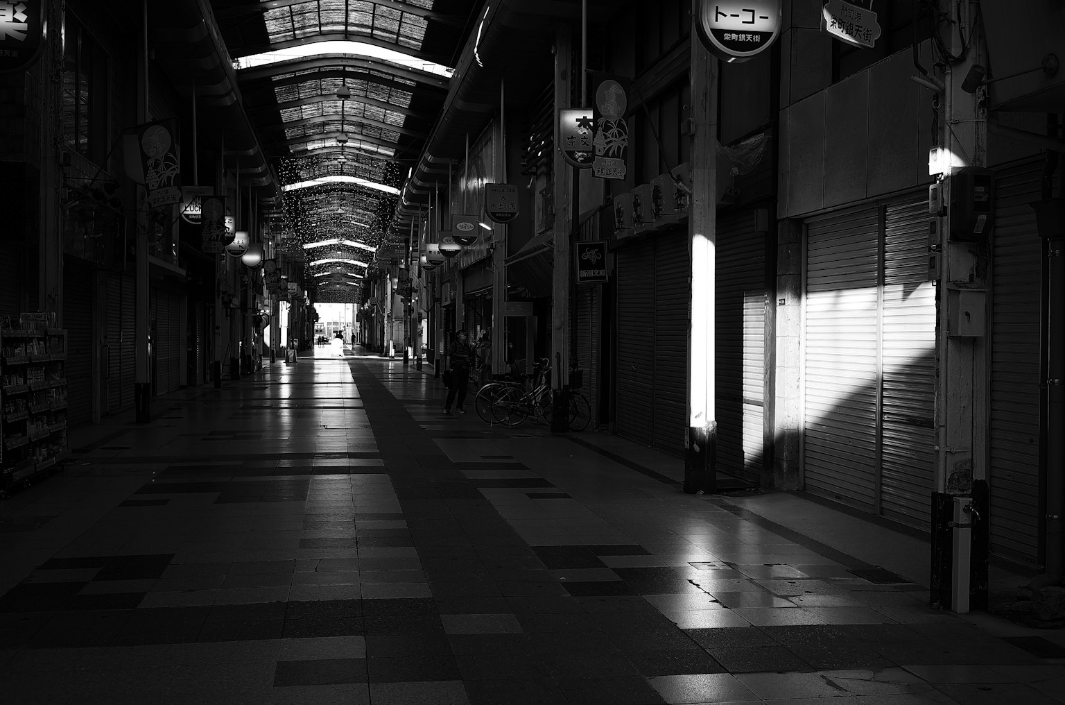 Lungo corridoio vuoto di una strada commerciale con luce che si riflette sul pavimento