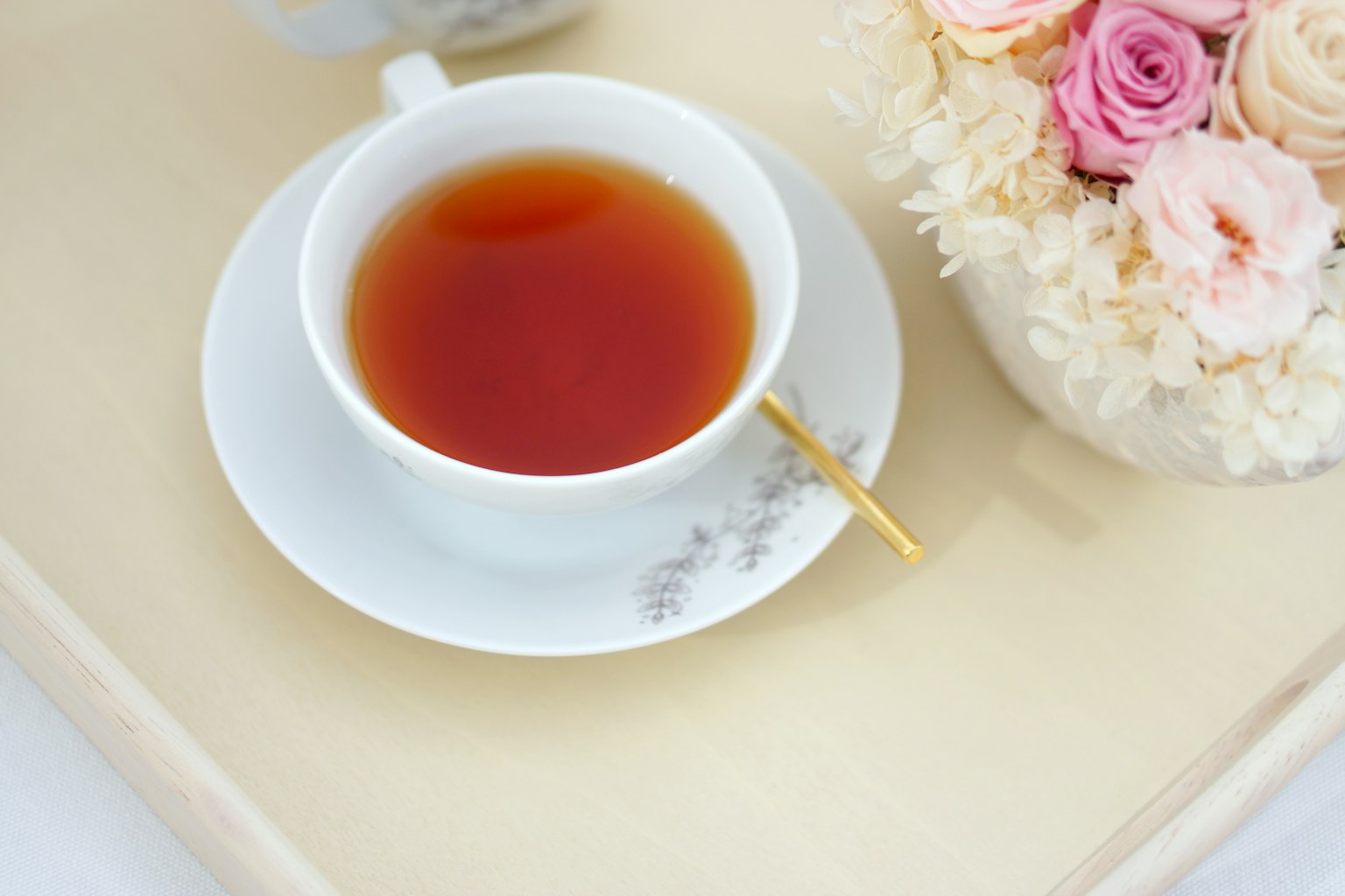 Elegante Tischdekoration mit einer Teetasse und Blumengebinde