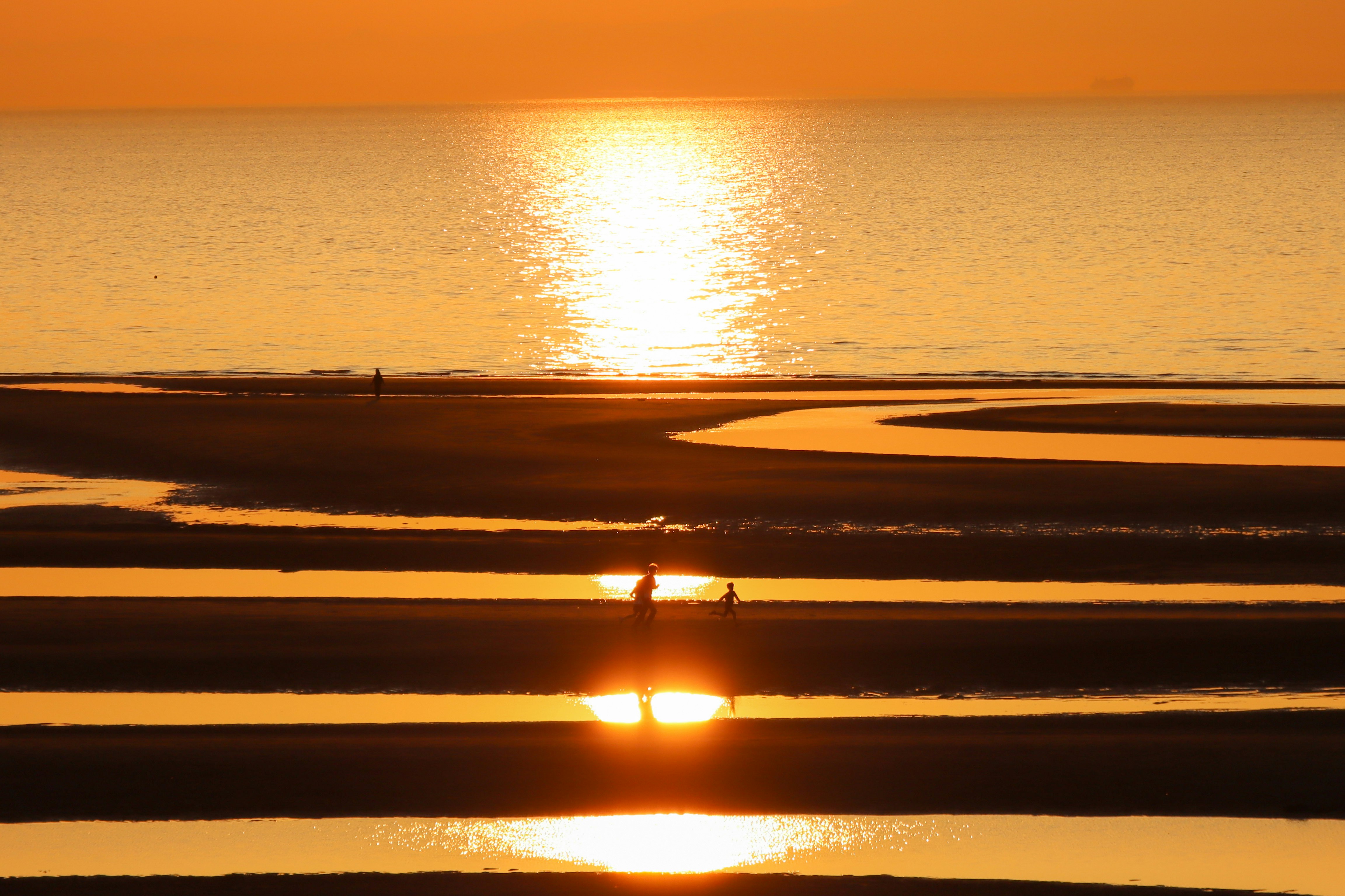 sunset over the shoreline at the beach
