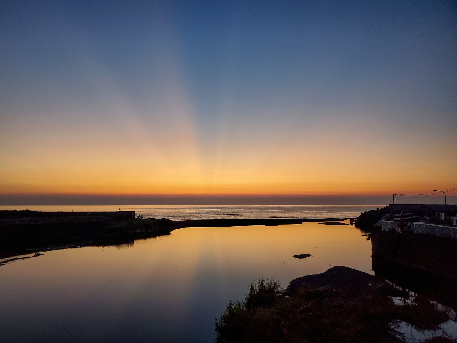 Mare calmo con un bellissimo riflesso del tramonto sull'acqua