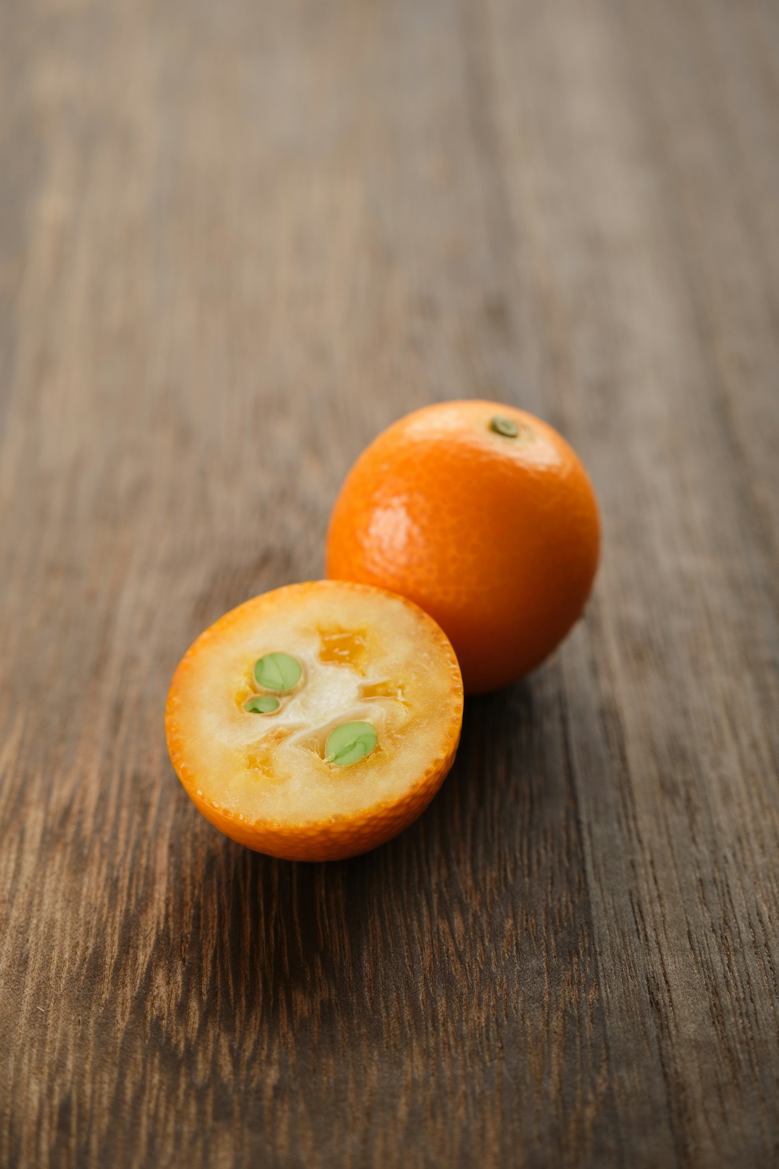 Fruit orange et sa moitié sur une table en bois