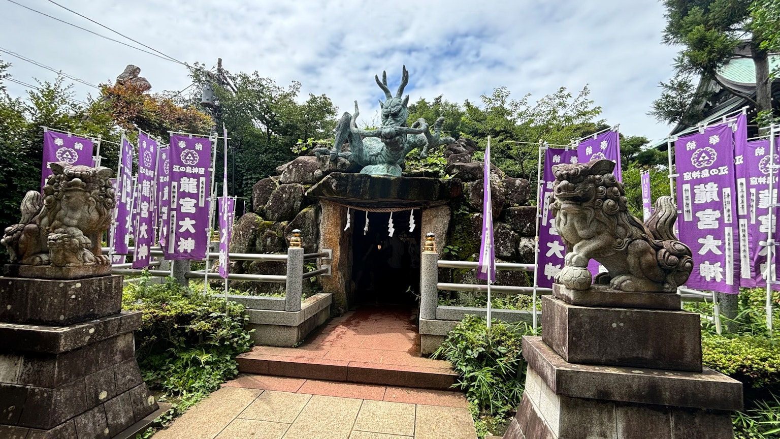 神社入口有石狮和紫色横幅