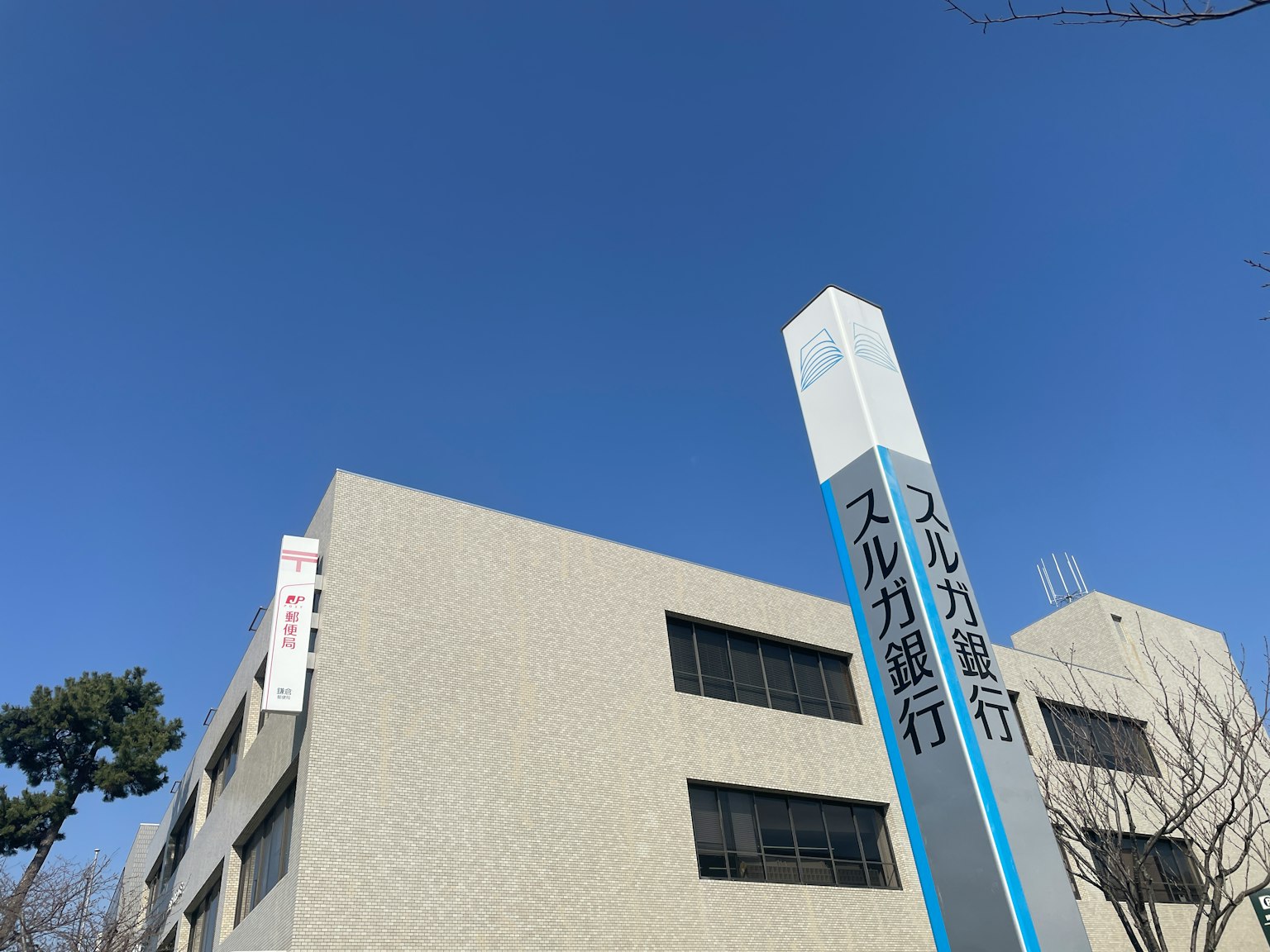 Extérieur d'un bâtiment moderne sous un ciel bleu clair avec un panneau bancaire