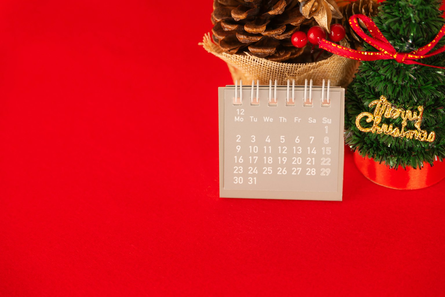 Kalender dan dekorasi Natal di latar belakang merah