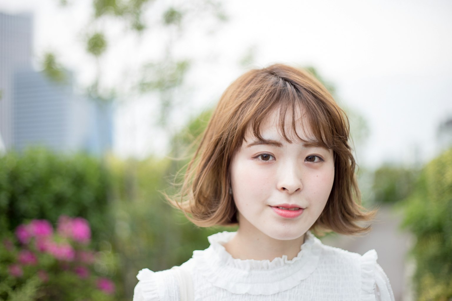 女性的肖像，站在绿色背景前，短发和柔和的表情