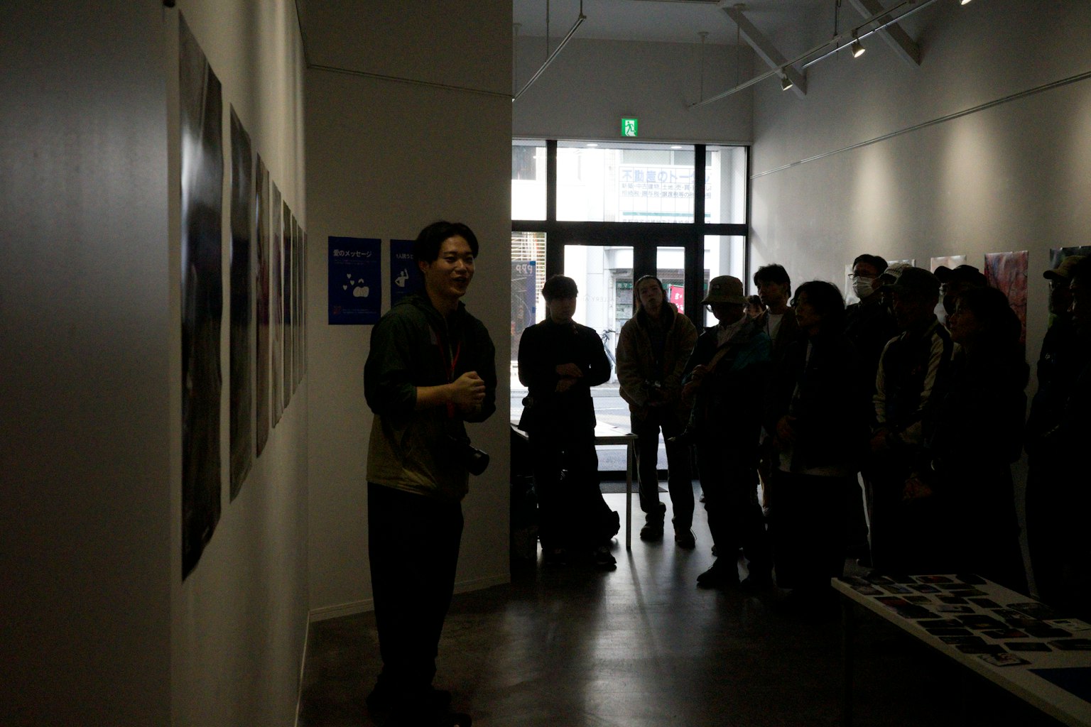 Hombre hablando en una galería de arte con una audiencia reunida
