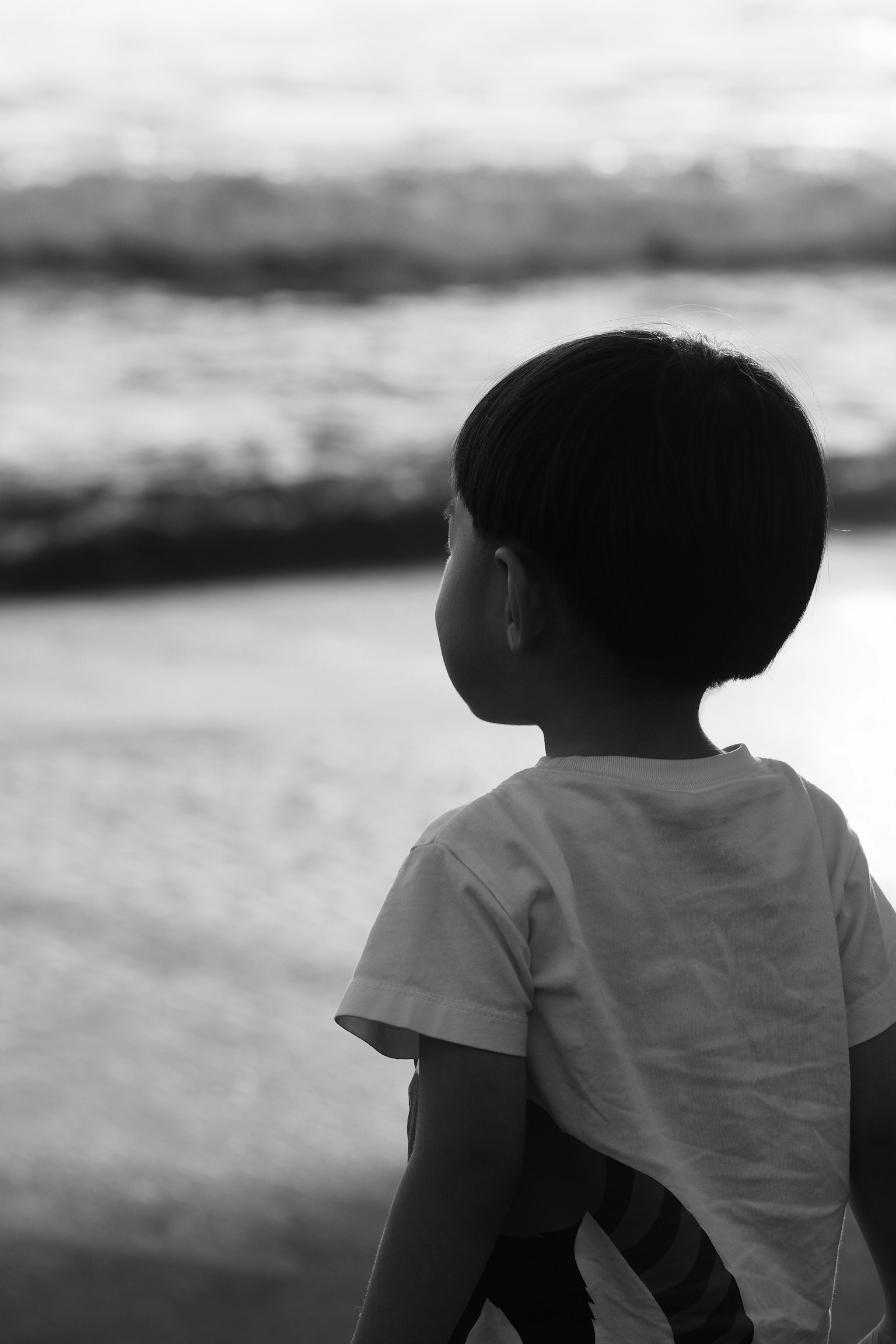 Enfant regardant la mer en noir et blanc