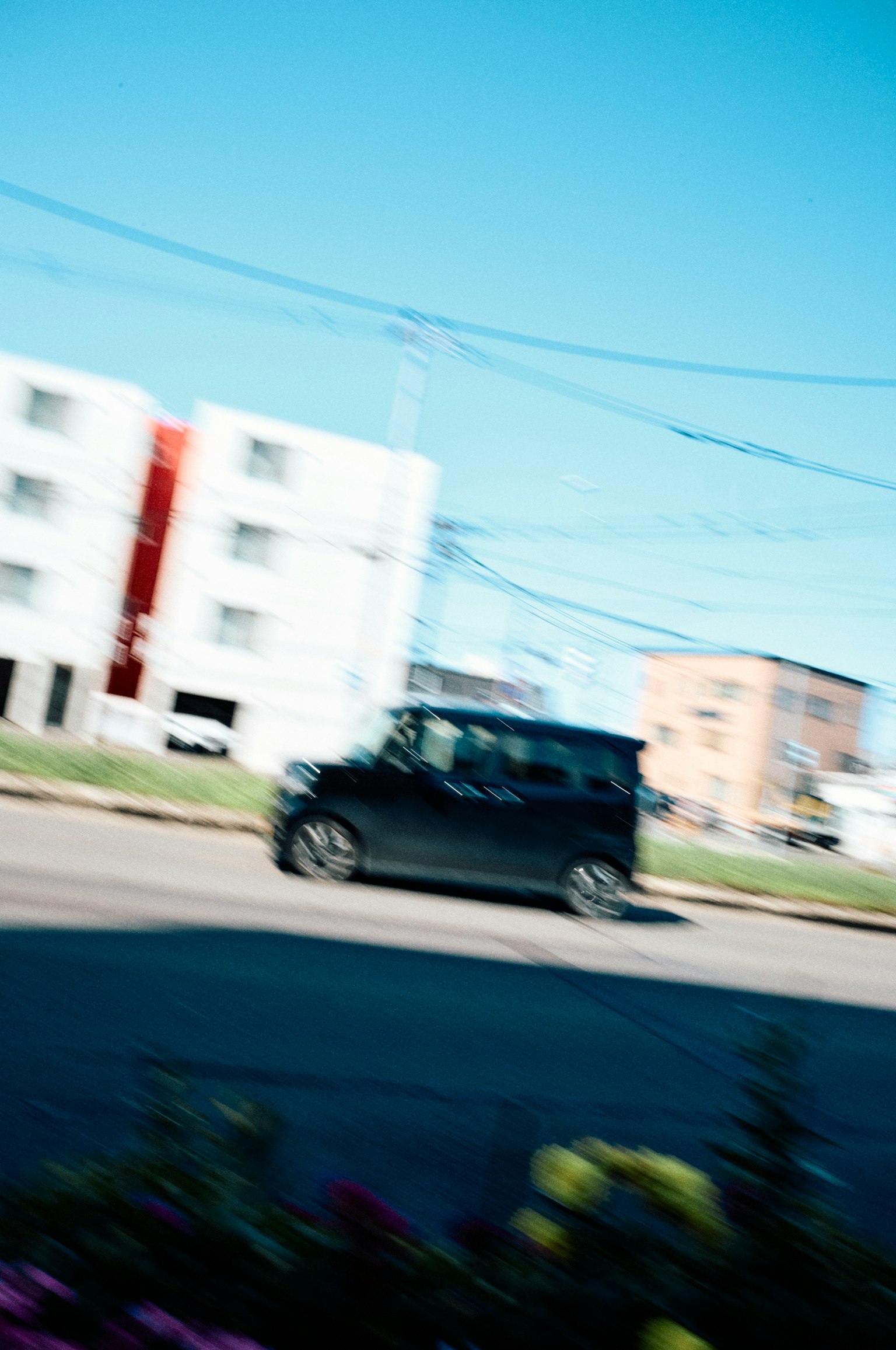 Un coche negro pasando por una escena de calle