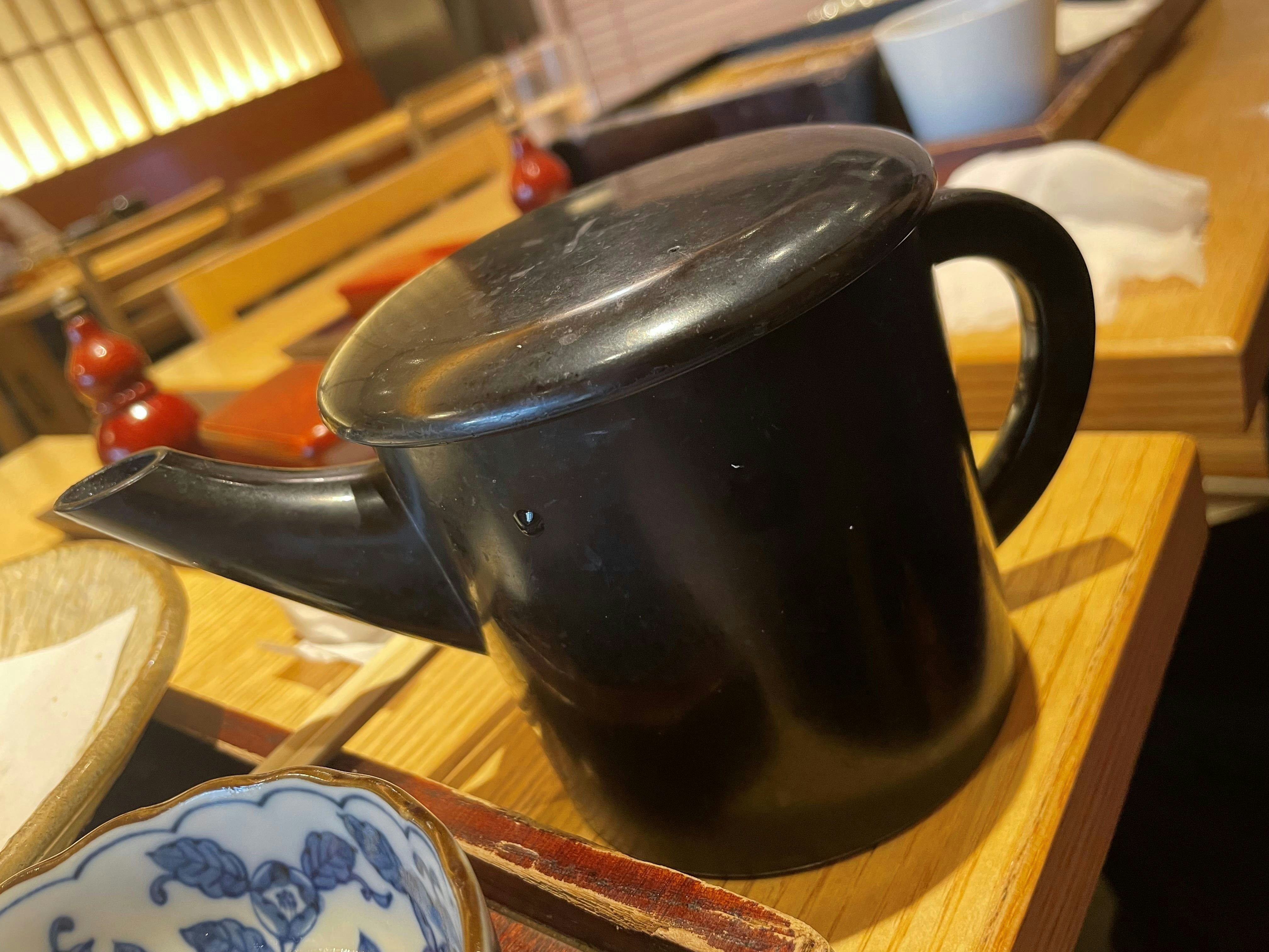 木托盤上的黑色茶壺和茶杯