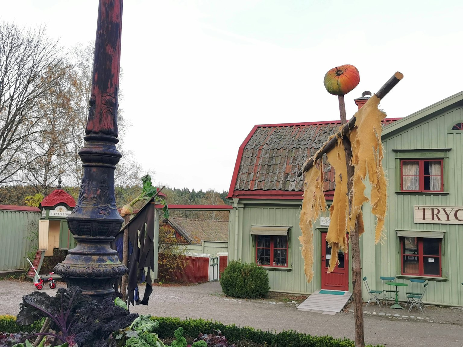 Vue pittoresque avec un poteau en bois portant une pomme orange et des feuilles sèches