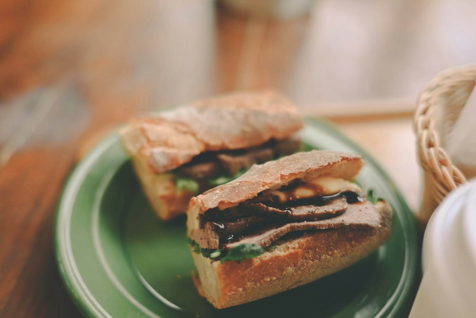 Panino su un piatto verde con strati di carne e verdure