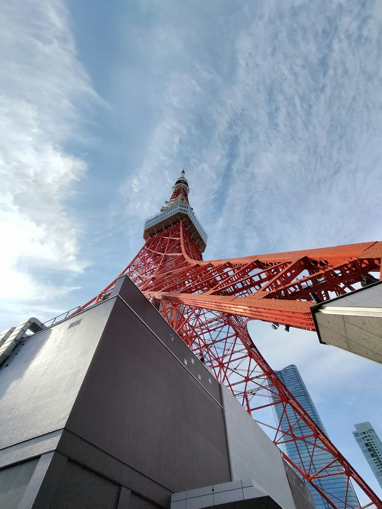 Vista de la Torre de Tokio desde abajo con cielo azul y nubes