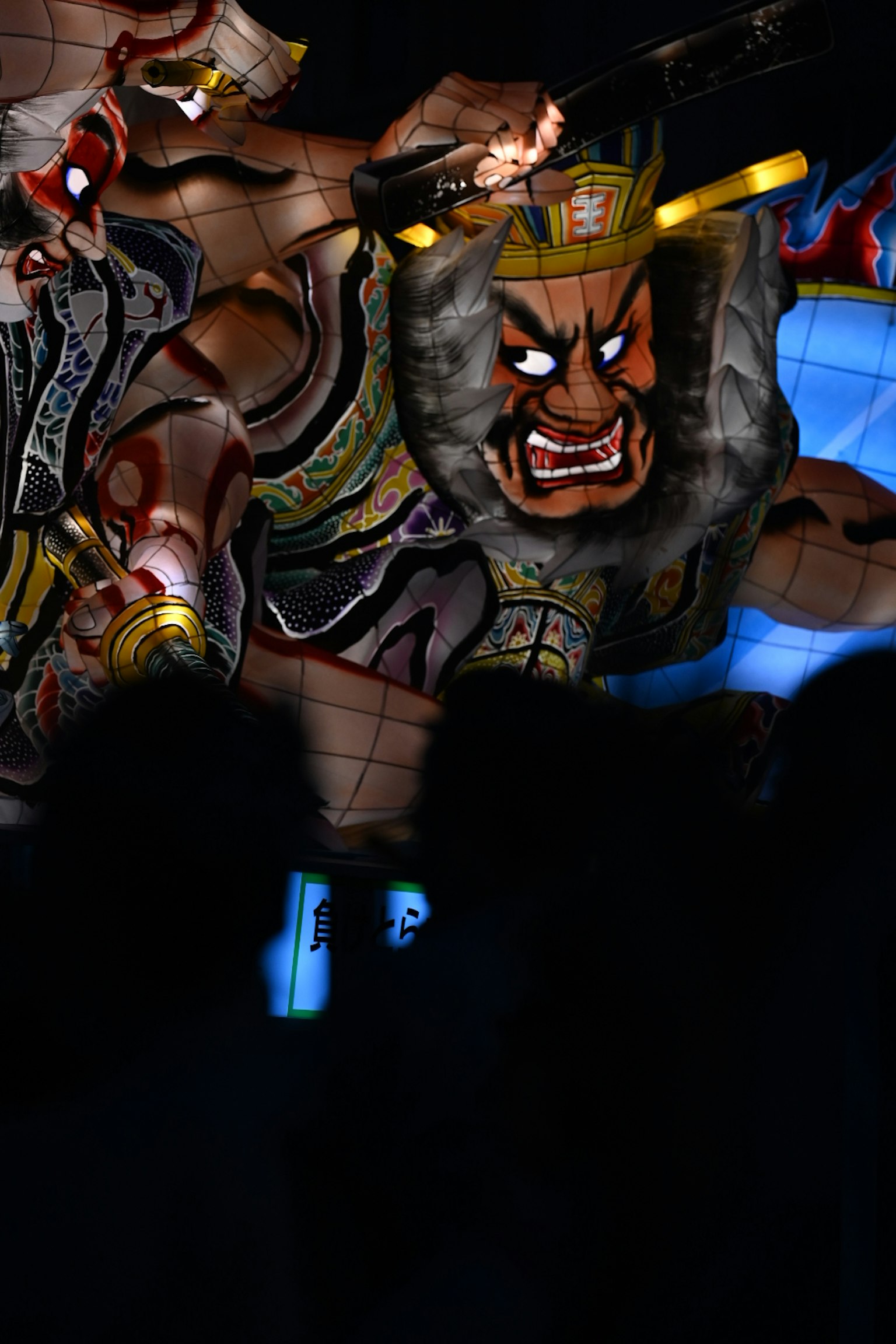Large illuminated warrior lantern display against a dark background