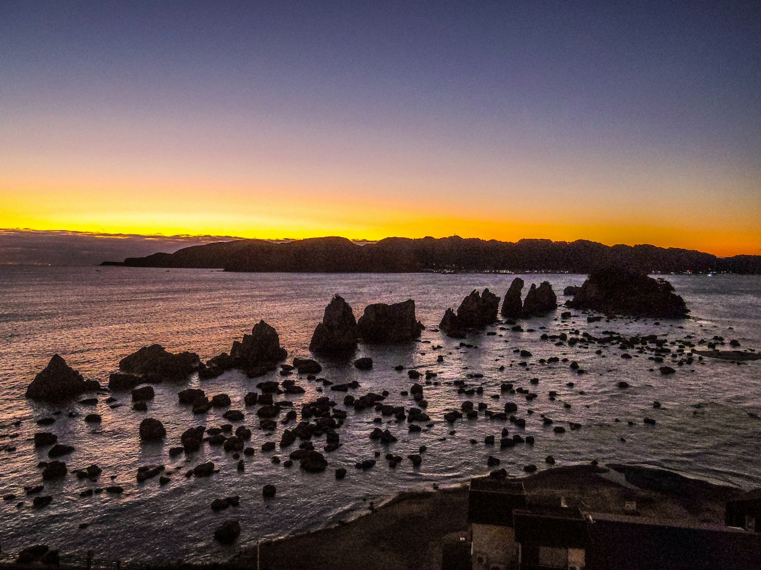 Rocas costeras al atardecer con olas tranquilas