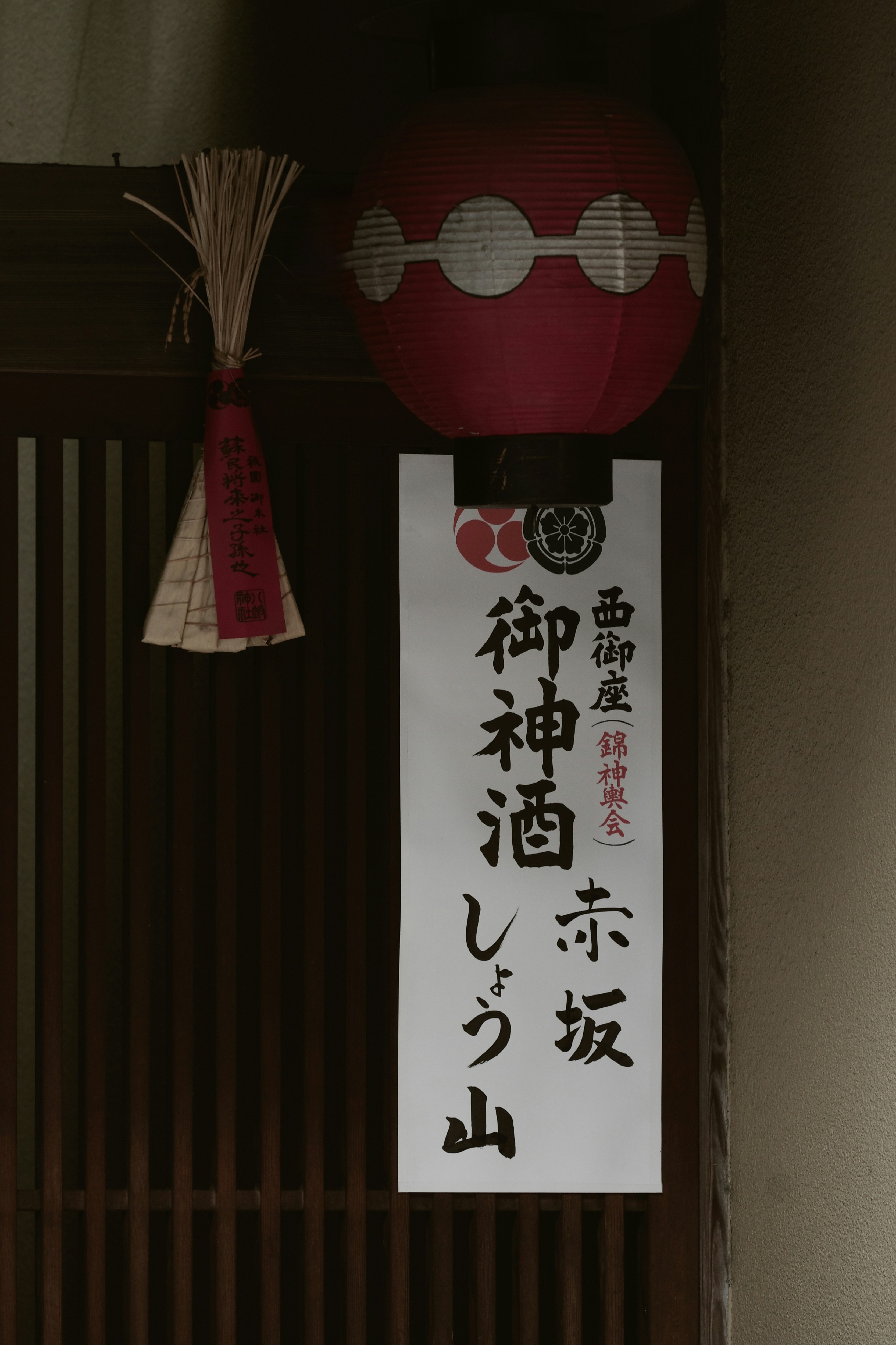 红色灯笼与写有「御神酒しづ山」的牌匾挂在门帘上