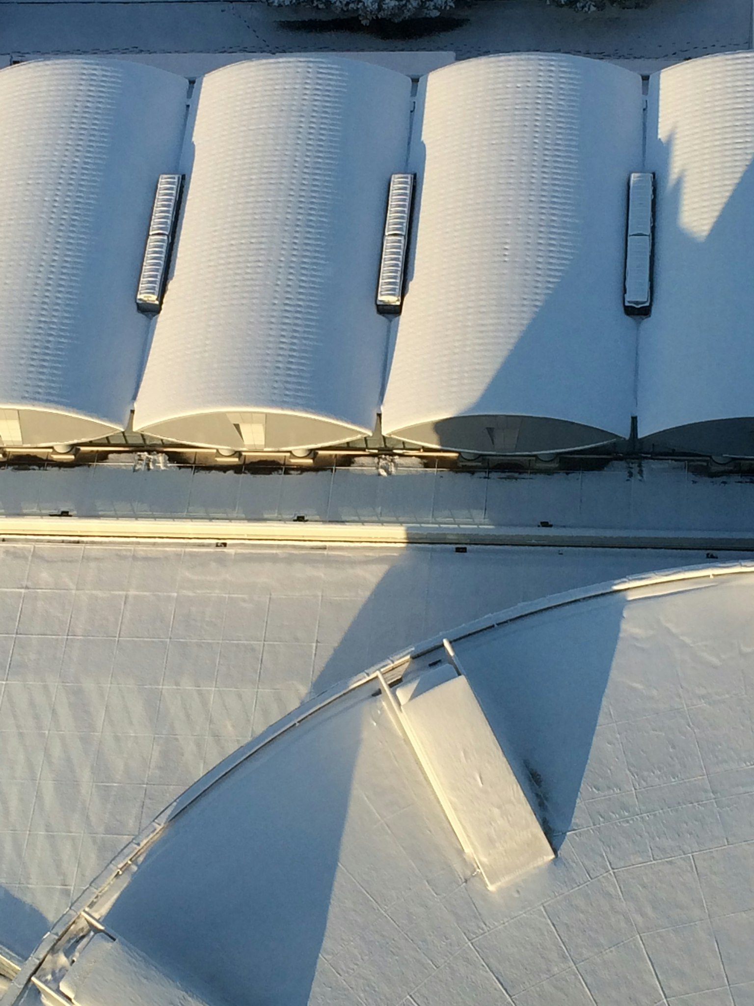 Vista aérea de techos cubiertos de nieve y estructuras con sombras