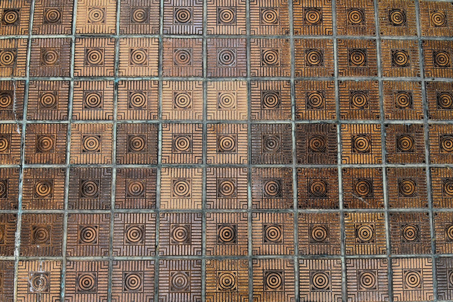 Floor covered with intricate patterned tiles arranged in a grid