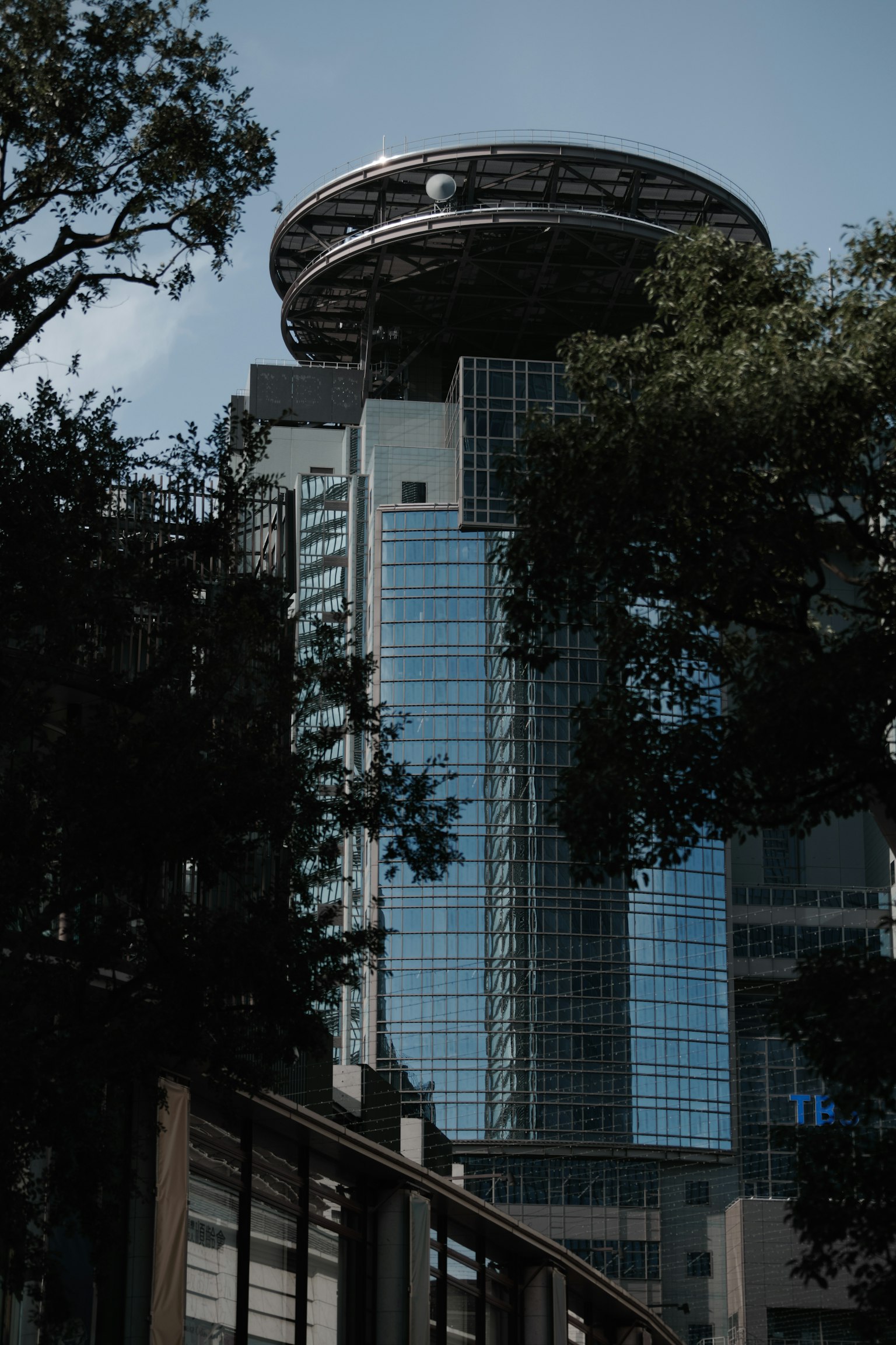 Urban landscape featuring a modern building with a circular structure on top