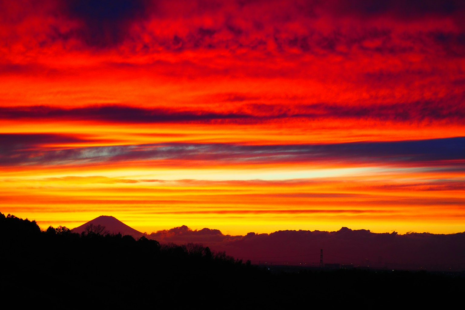 赤とオレンジの壮大な夕焼けが広がる山の風景