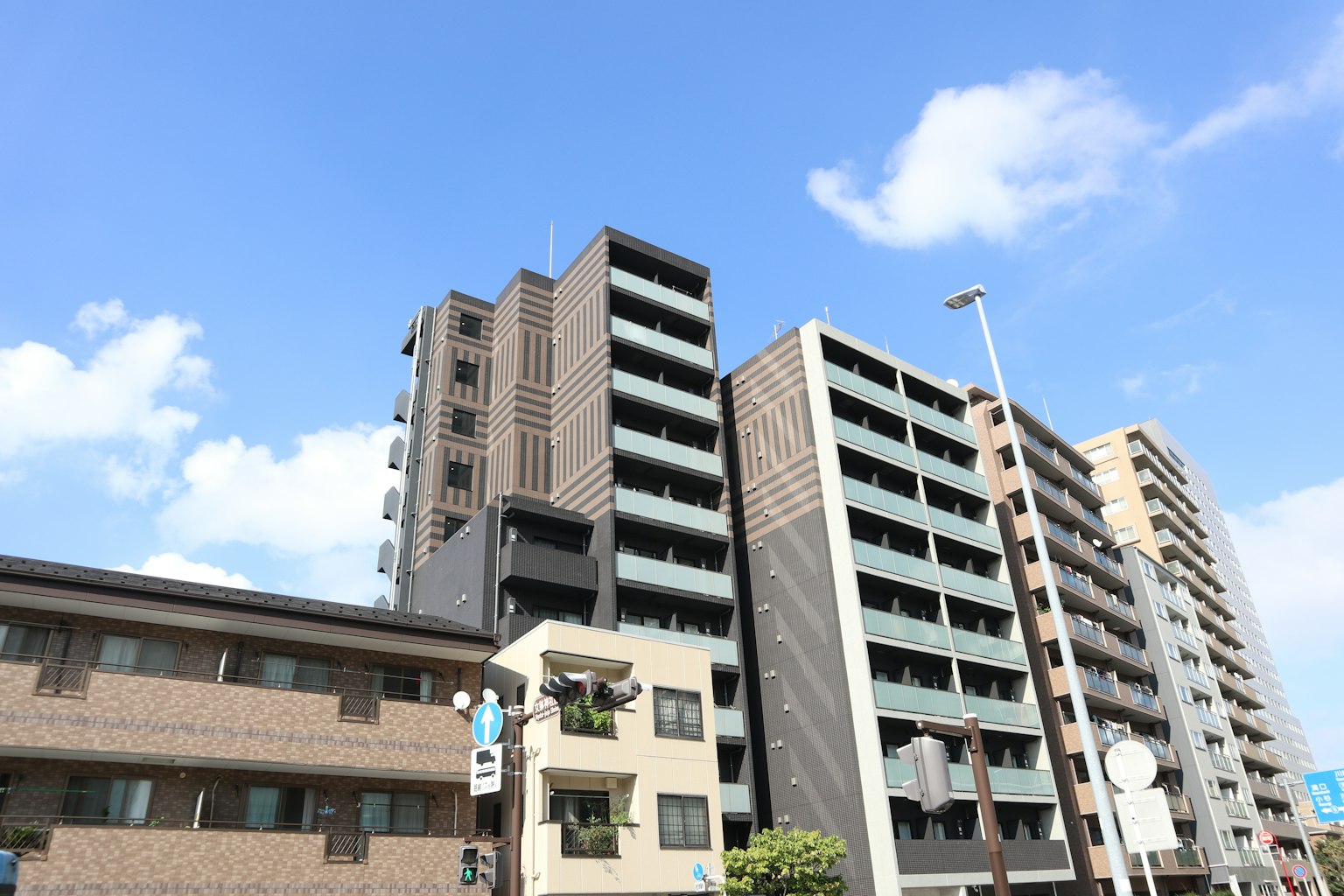 Edificio moderno a più piani sotto un cielo blu con un edificio tradizionale a bassa altezza