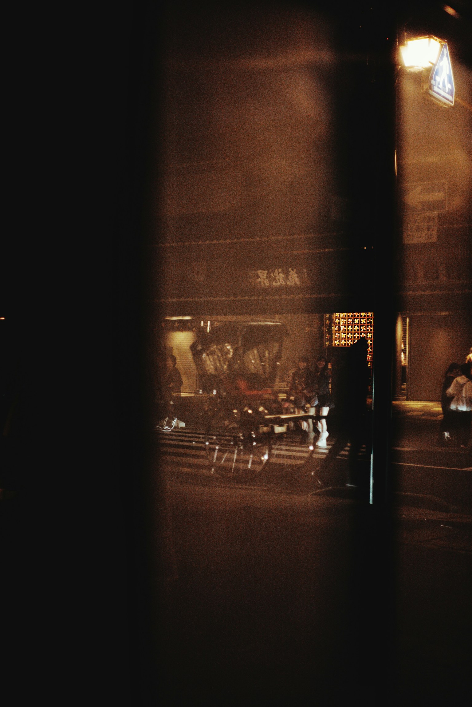 Vista de la calle a través de una ventana mostrando la vida urbana y personas