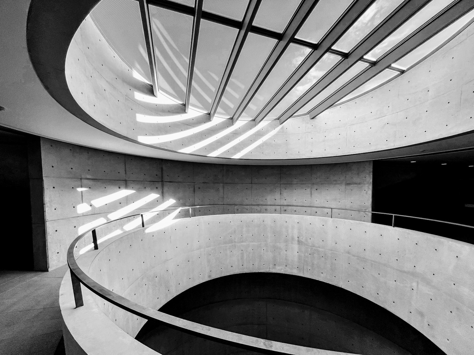 Modernes architektonisches Innendesign mit geschwungener Treppe und linearen Lichtstreifen