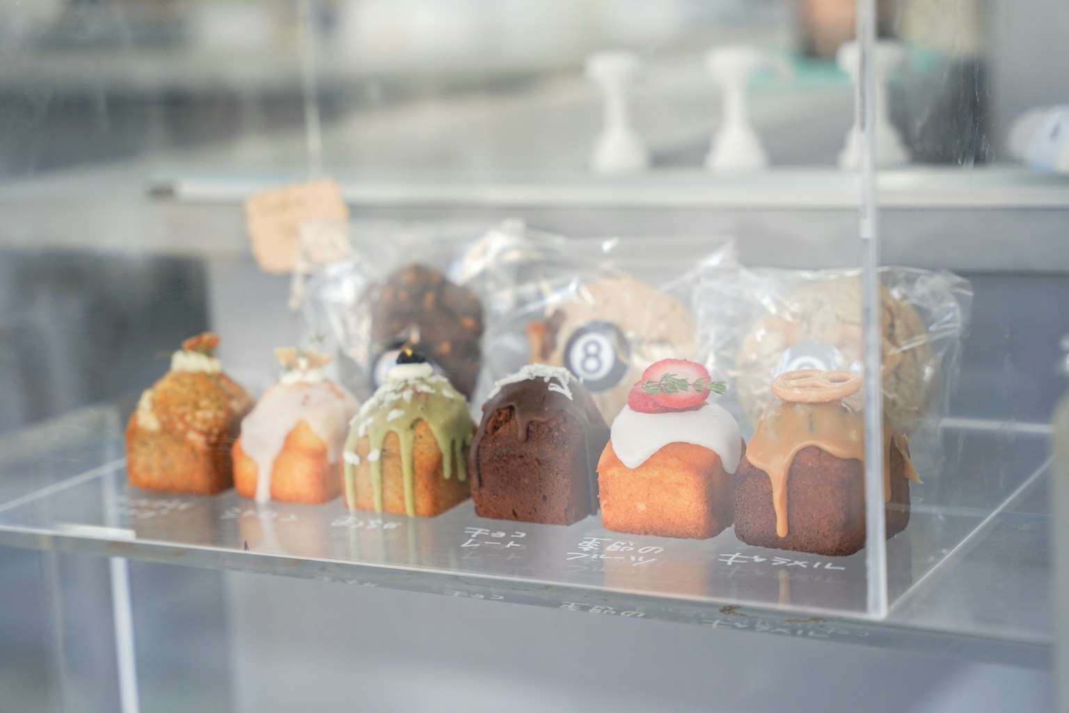 Kue kecil berwarna-warni yang dipajang dalam kotak transparan