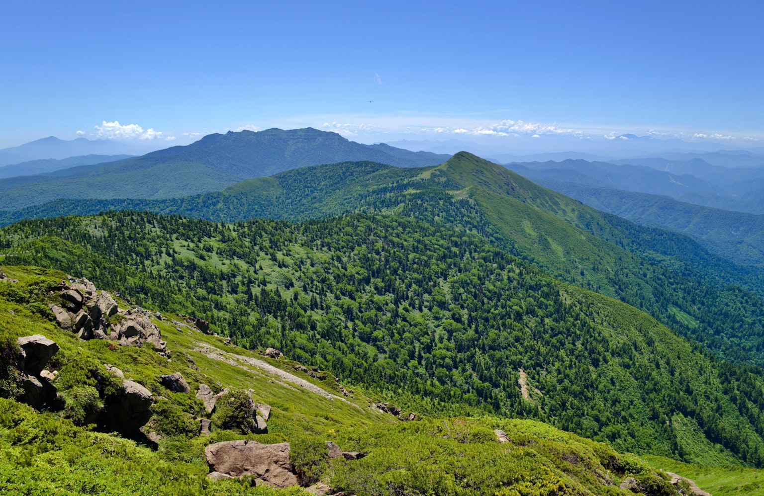 Montañas verdes bajo un cielo azul claro