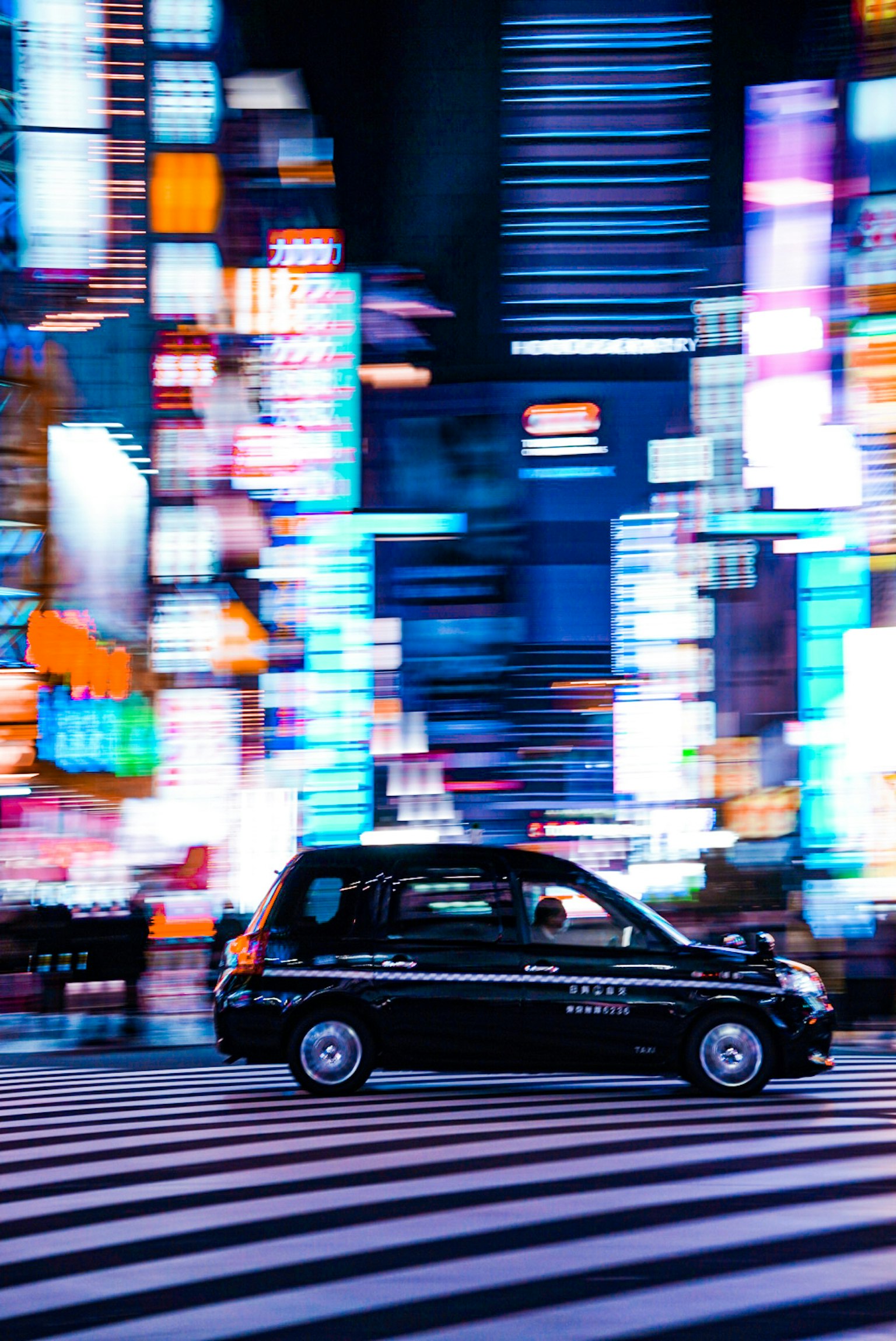Taxi noir circulant dans les rues illuminées de néons de Tokyo la nuit