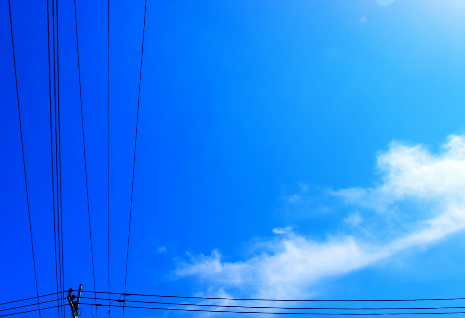 Langit biru dengan awan putih dan kabel listrik