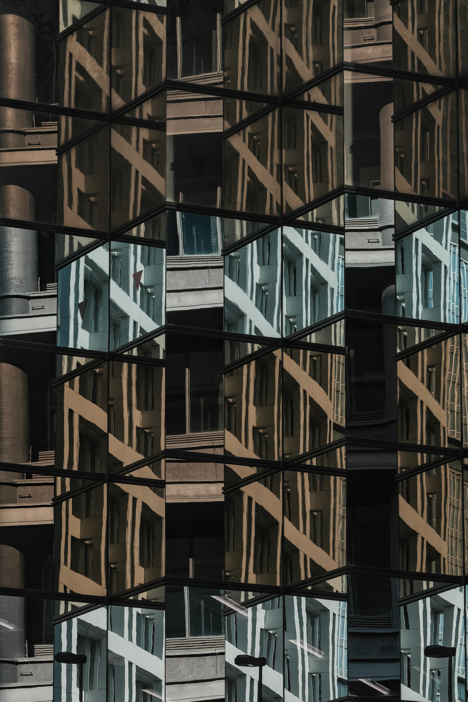 Modern facade with intersecting reflections of glass and wood buildings