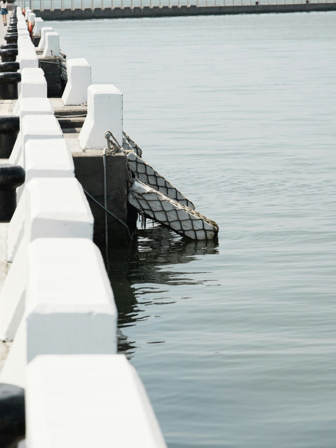 white seawall and calm ocean surface view