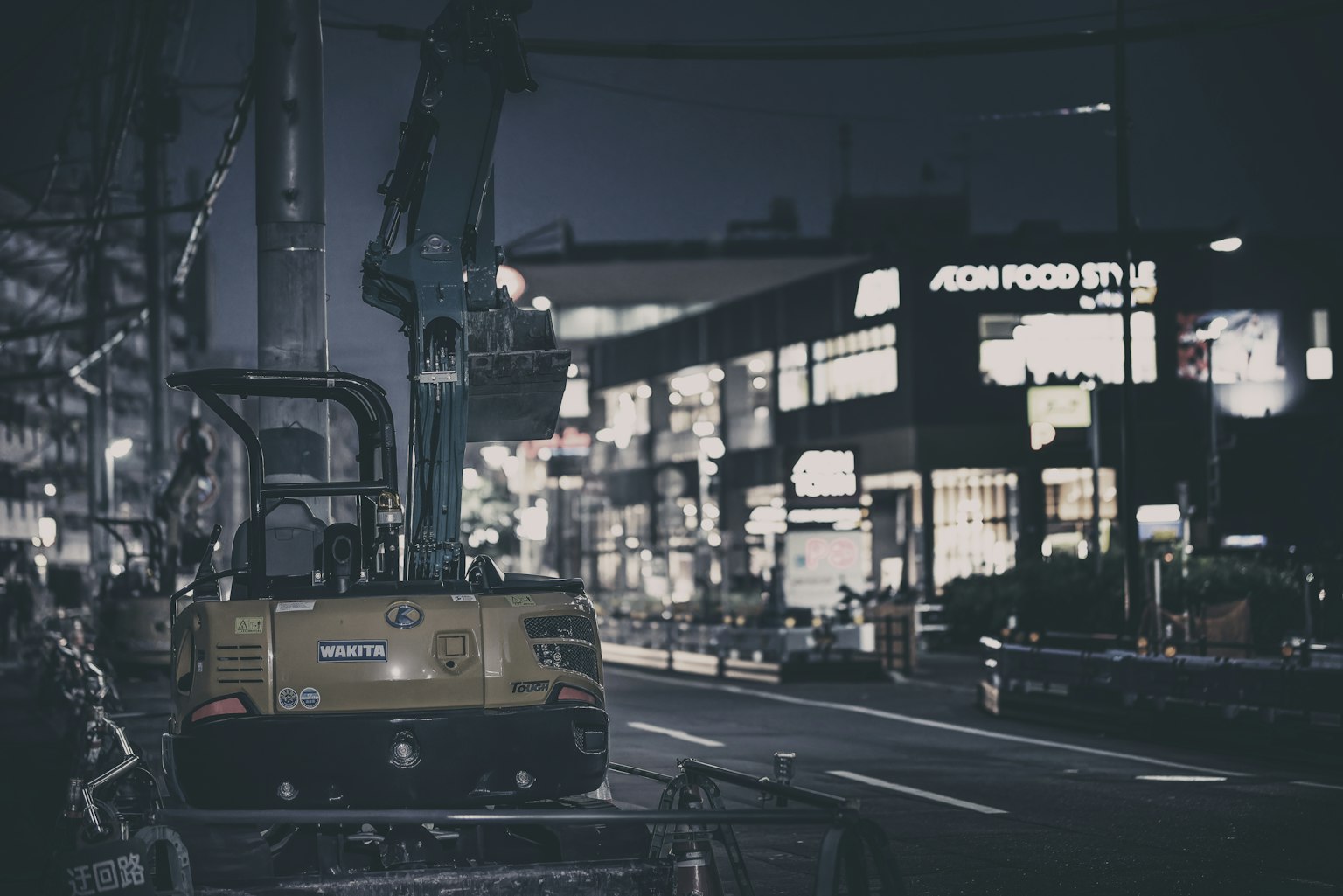 Scène urbaine nocturne avec équipement de construction et vitrines illuminées